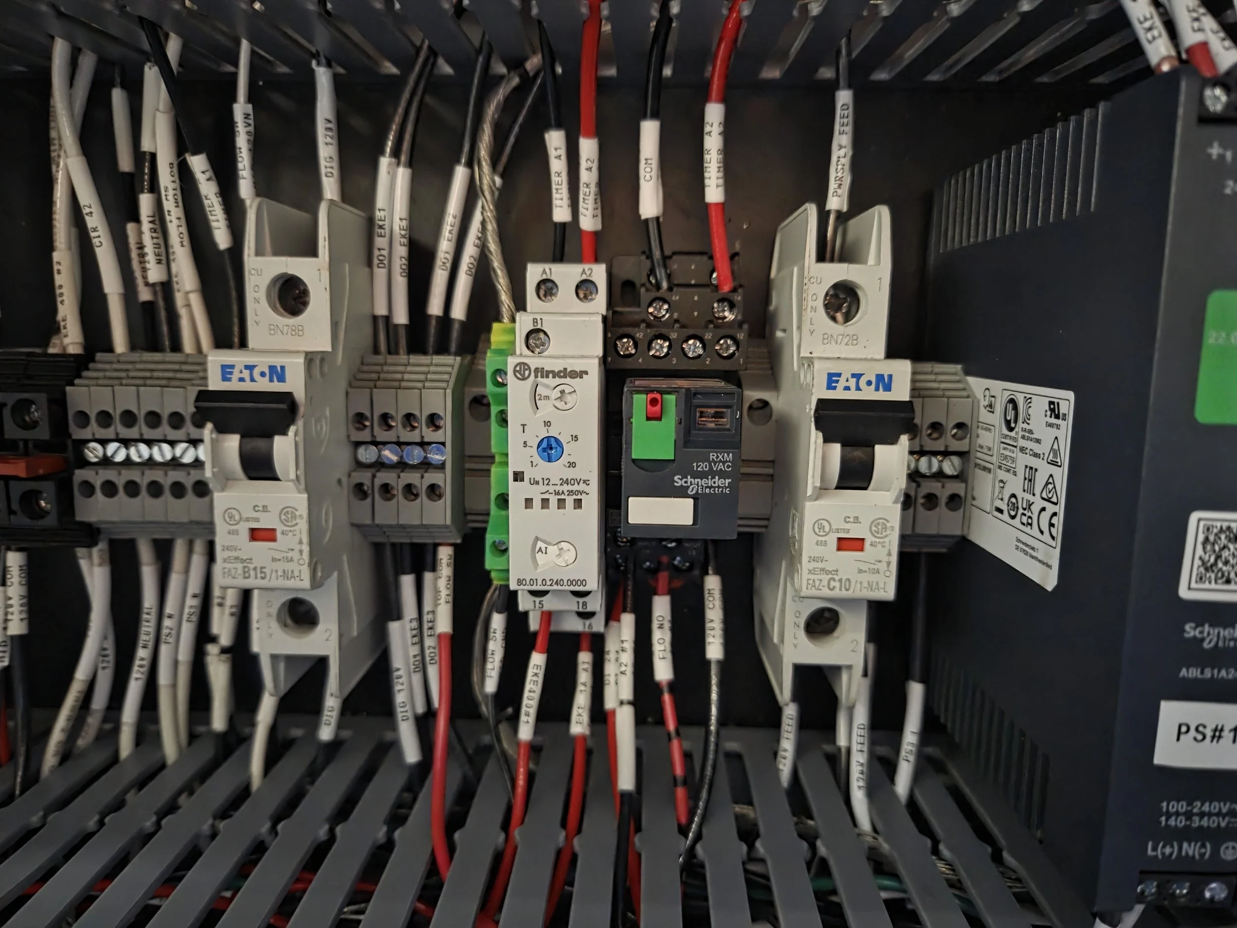 Close-up view of an electrical control panel with various wires, terminal blocks, and electronic components.