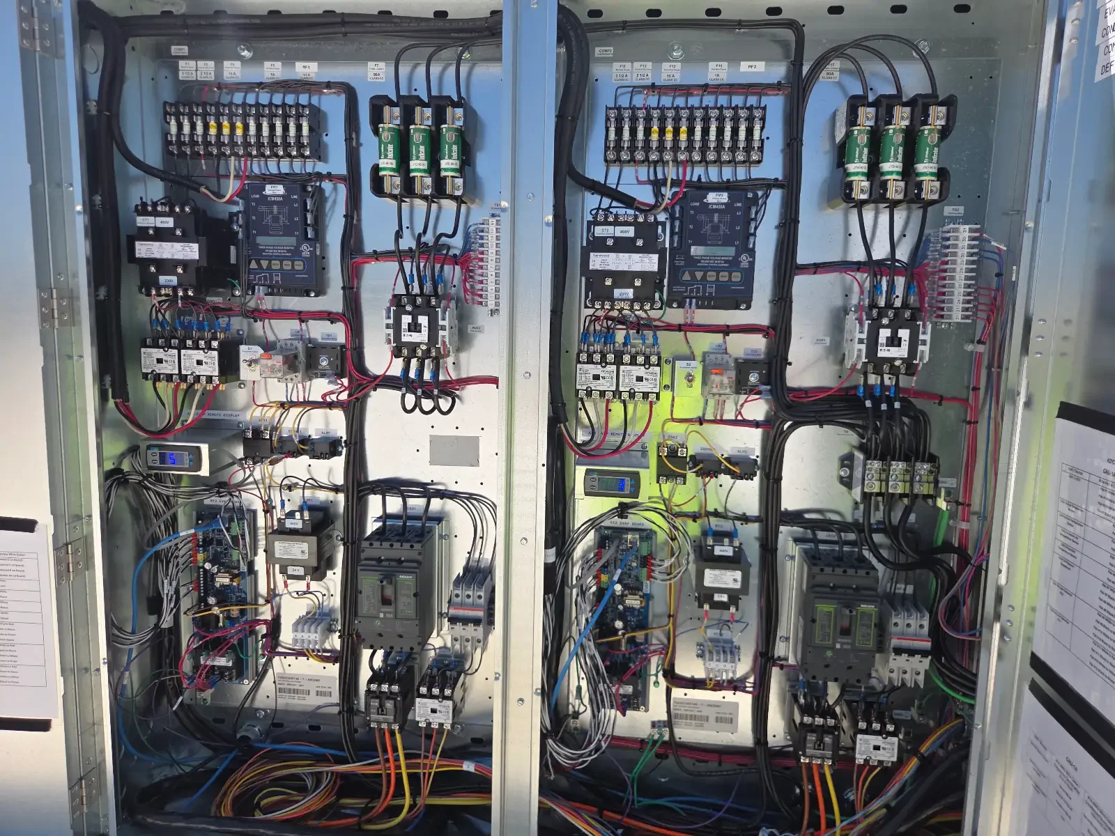 Interior of an electrical control panel with various wires, circuit breakers, and electrical components.