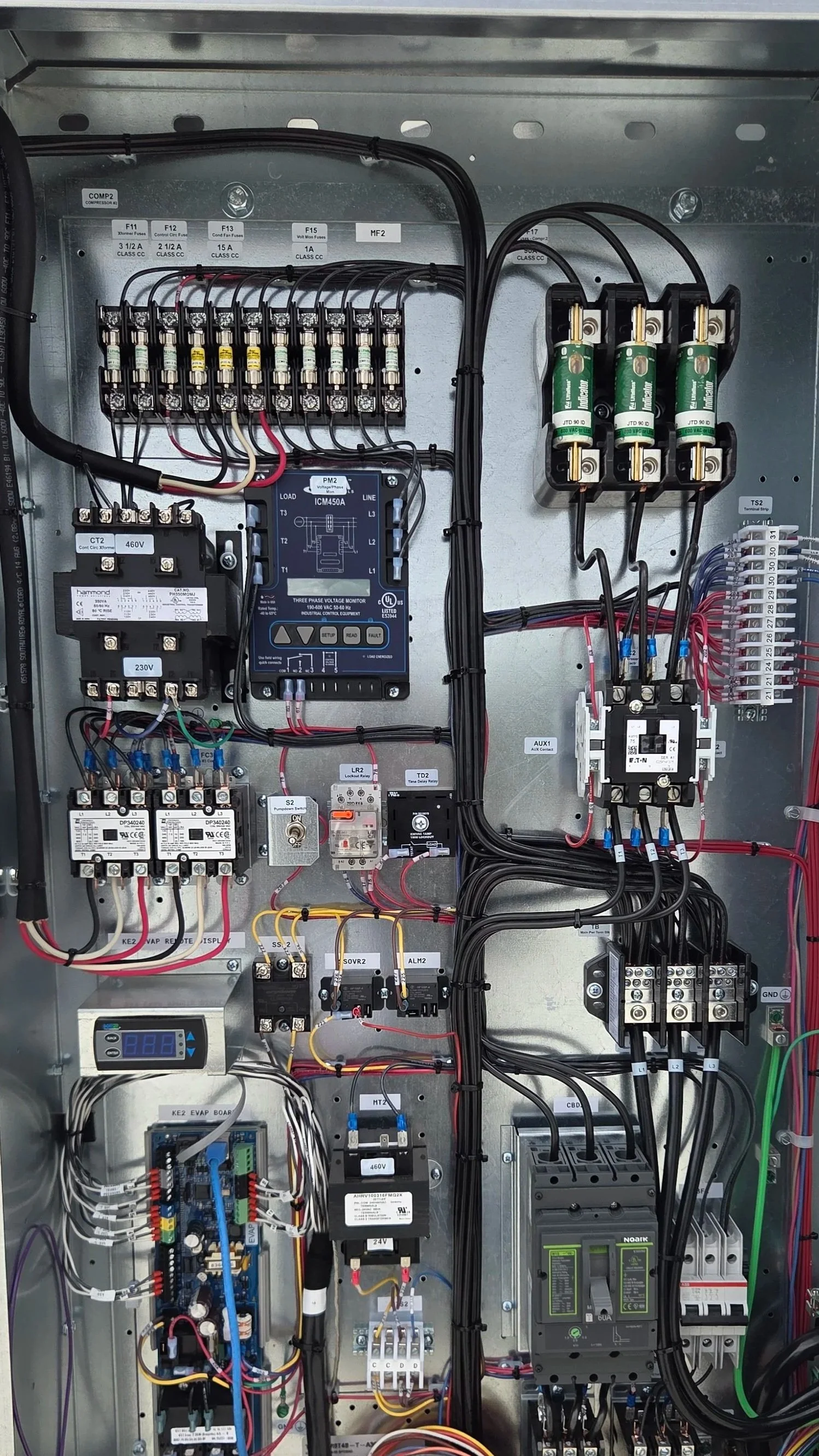 Electrical control panel with various wires, switches, and electronic components.
