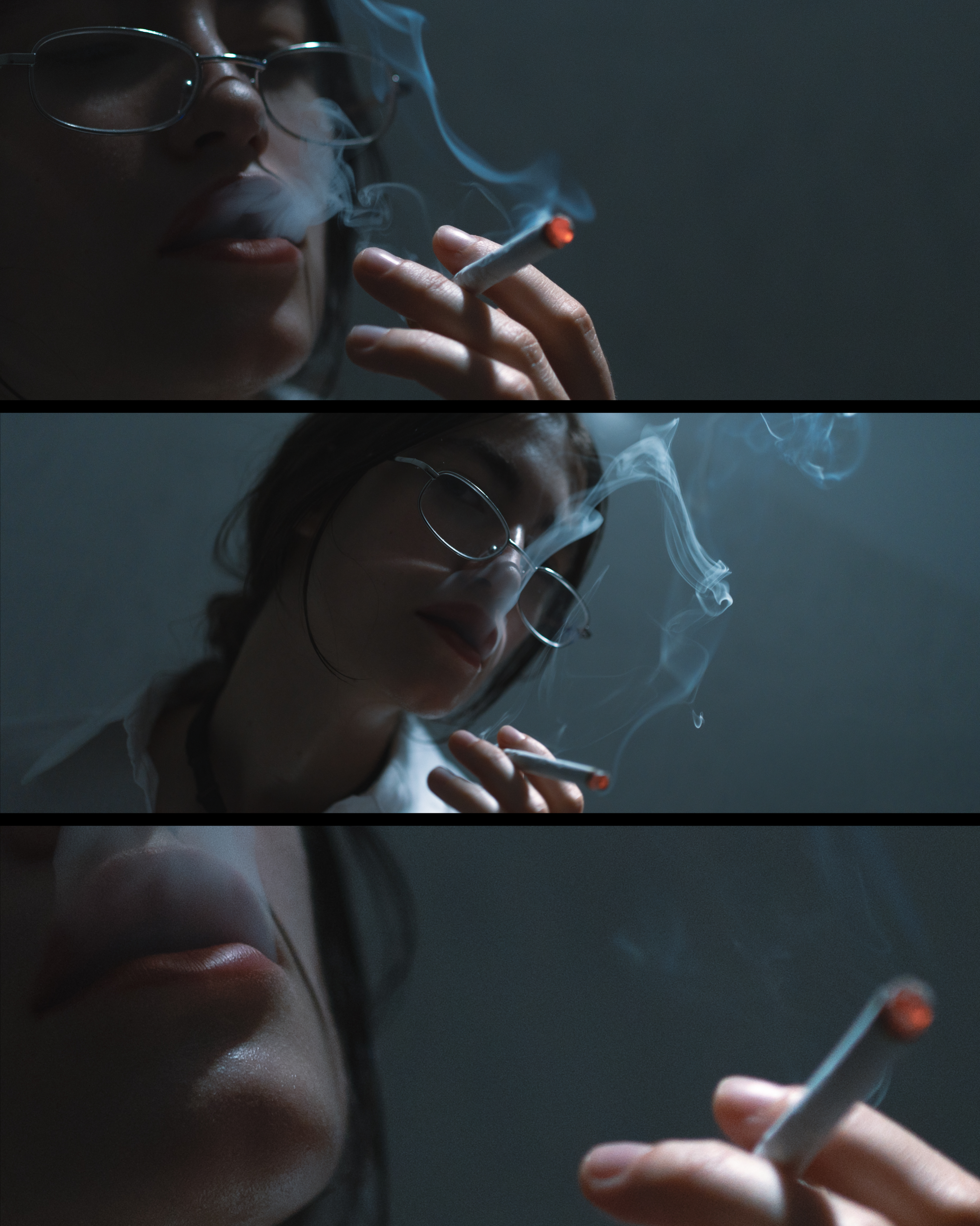 Close-up of a woman with glasses smoking a cigarette, with smoke rising around her face, in a dark setting.