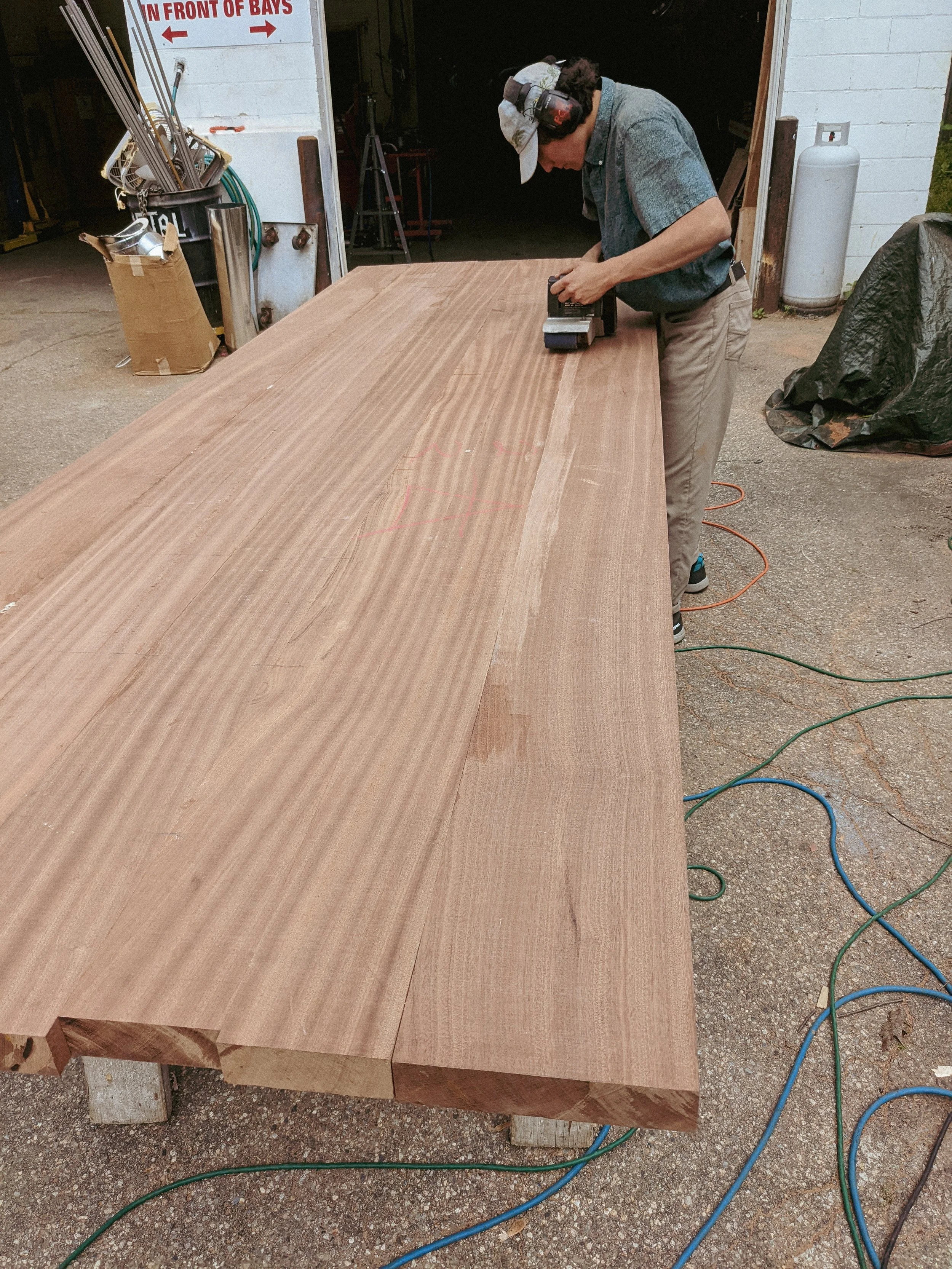 A man sanding down custom millwork at J.P. Smith Builders.