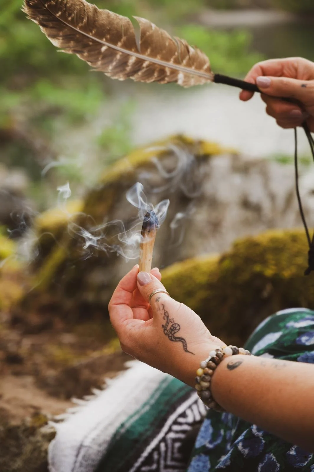a practitioner smudging with palo santo and feather
