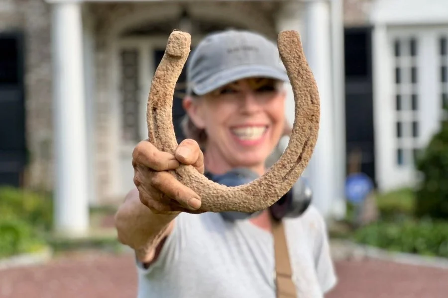 Lynne from Quarter Hoarder holding a horseshoe she found metal detecting at an 1800s homesite