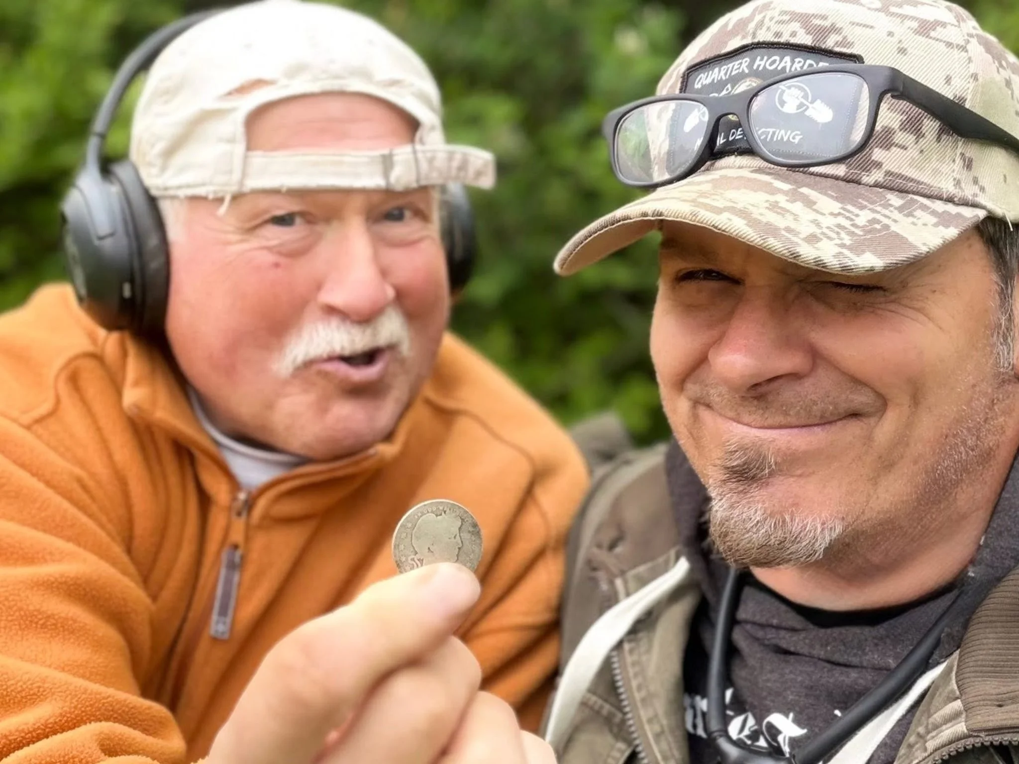 Dogtag Doug and Jason from Quarter Hoarder holding a silver Barber quarter found metal detecting