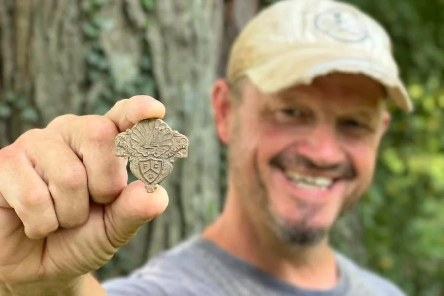 Matt from Quarter Hoarder holding a masonic medal from the 1920s he found metal detecting
