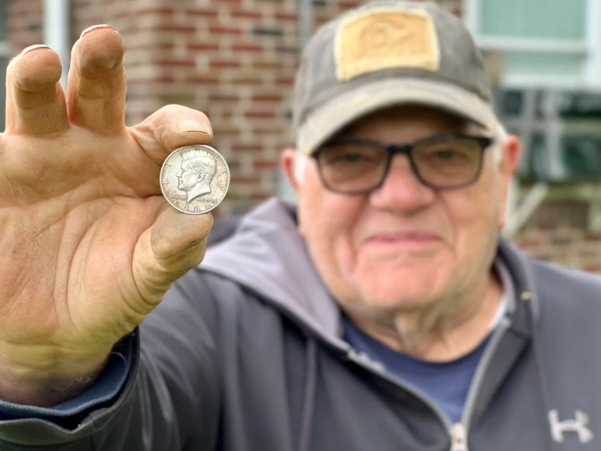 Charley From Quarter Hoarder Holding a Silver Kennedy Half Dollar He Found Metal Detecting