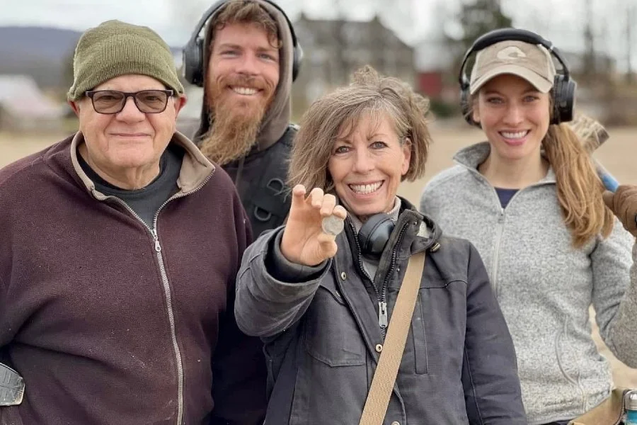 Lynne, Charley, Jessica, and Rich from Quarter Hoarder holding an 1800's Capped Bust half dollar that was found metal detecting a colonial farm field