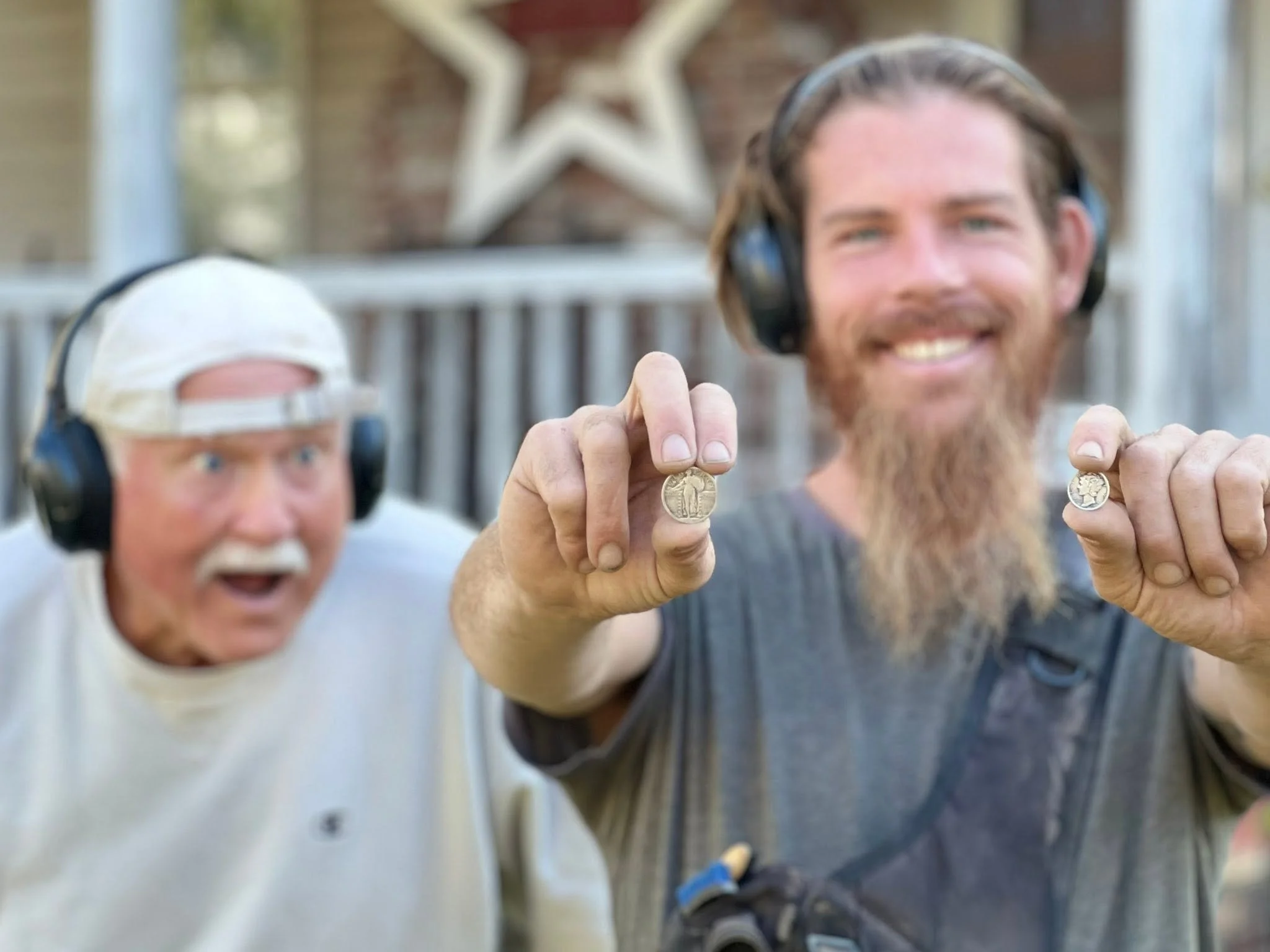 Rich VanWinkle and Dogtag Doug from Quarter Hoarder holding two silver coins from metal detecting