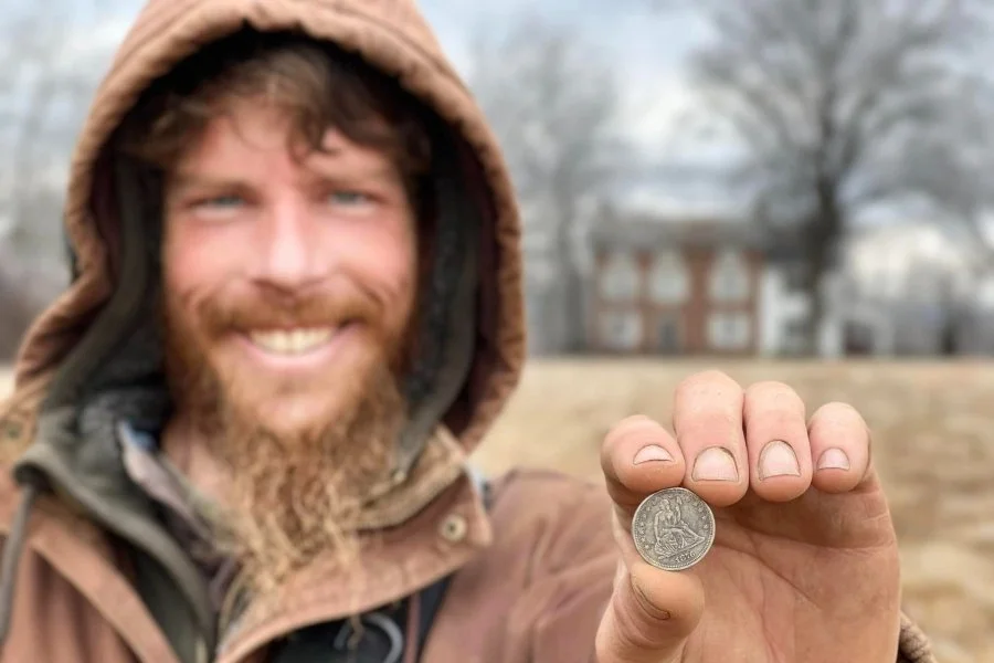 Rich VanWinkle from Quarter Hoarder holding a silver U.S Seated Quarter found metal detecting