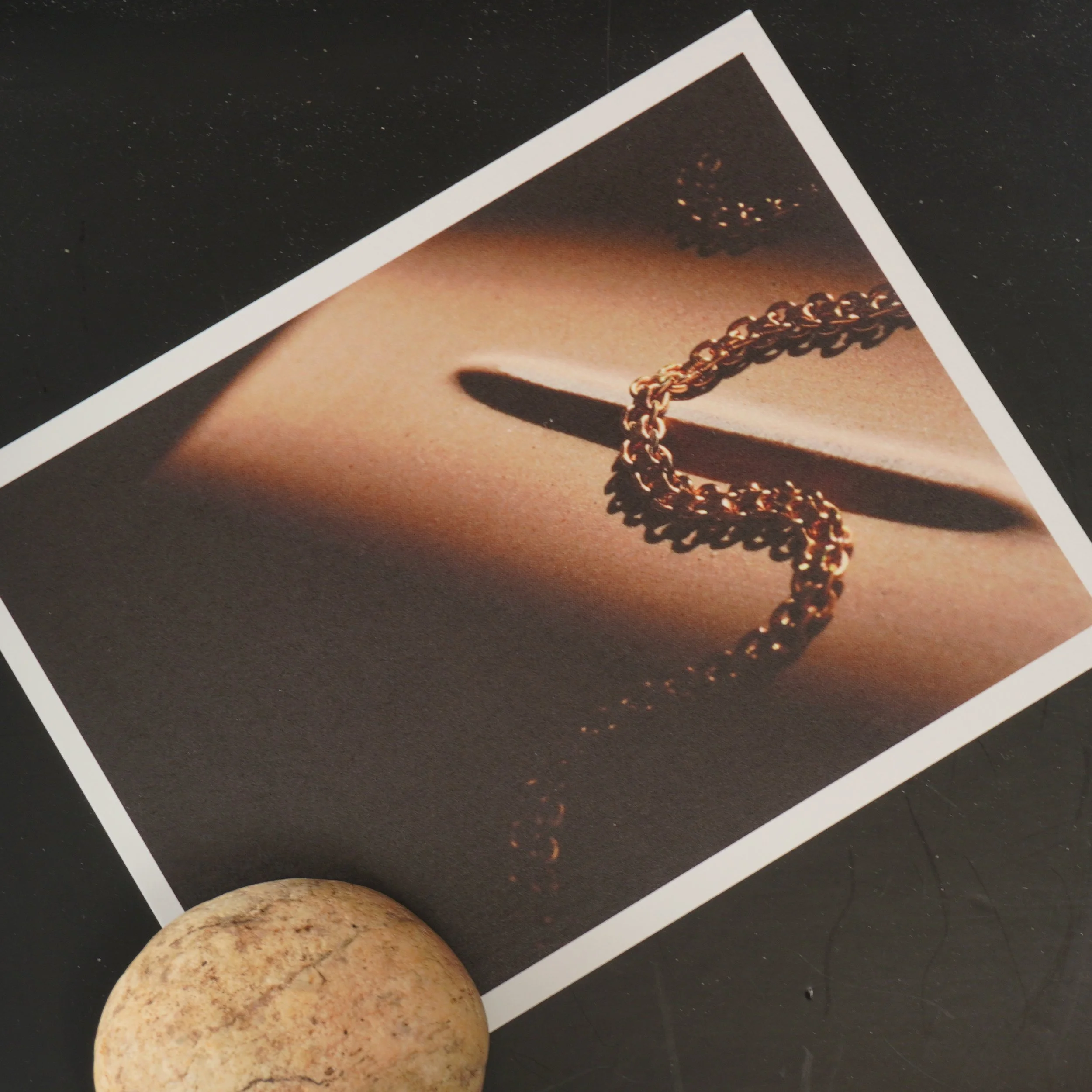 Photo of a social media advertisement featuring a close-up of a gold chain necklace, placed on a white surface against a dark background, with a bare potato in the foreground.