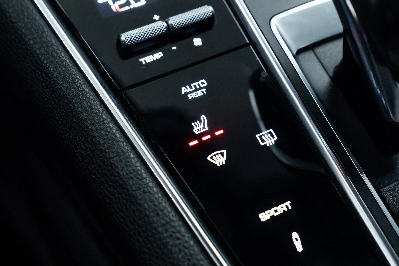 Car's climate control panel displaying heated seat and defrost icons.