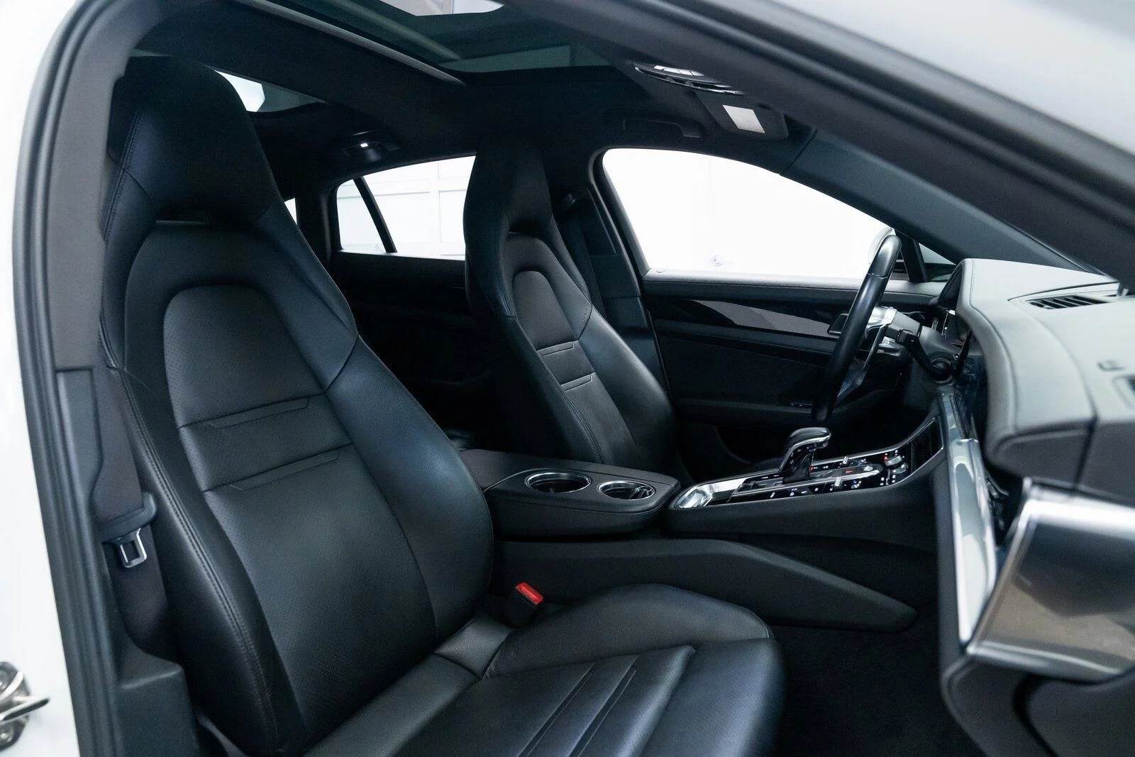 Interior of a luxury car featuring black leather seats, a modern dashboard, and a center console with controls.