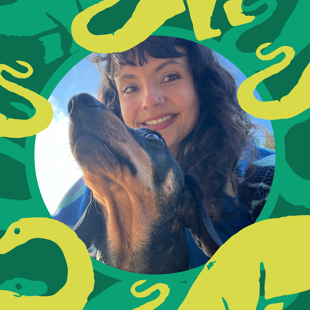 A woman with dark curly hair, wearing a nose ring, smiling with a happy dog, outdoors with blue sky in the background, surrounded by a colorful abstract border.