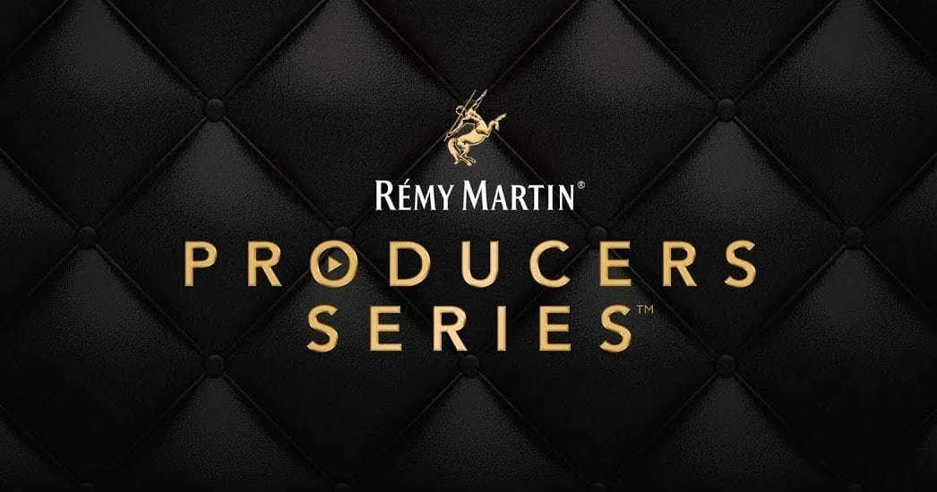 Remy Martin Producers Series logo on a black quilted background with a gold emblem of a deer.