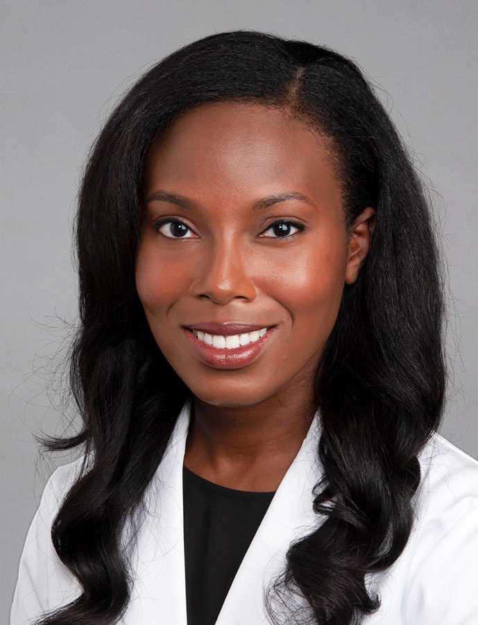 Dr. Rechelle Tull, a smiling woman with long, wavy black hair wearing a white coat.