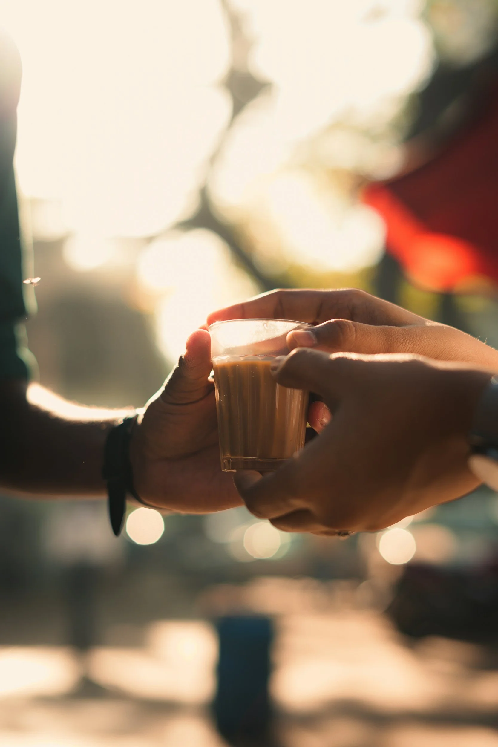 Two people sharing a glass of chai in India