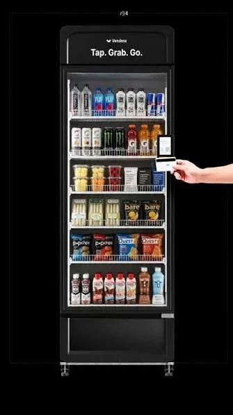 Vending machine with snacks and beverages, including energy drinks, bottled water, and chips.
