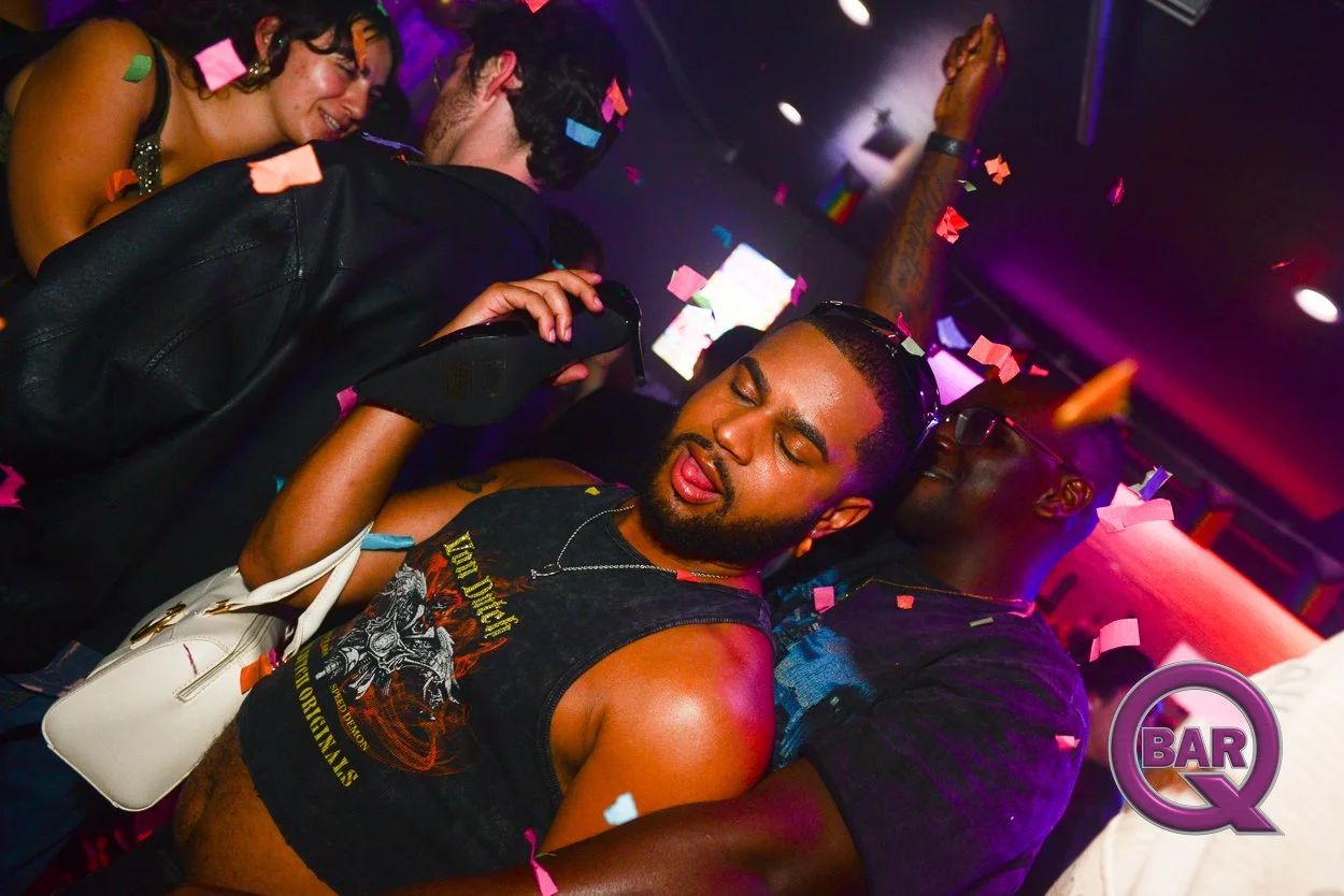 People dancing at a nightclub with colorful confetti falling, showing a diverse group enjoying themselves in a vibrant setting.