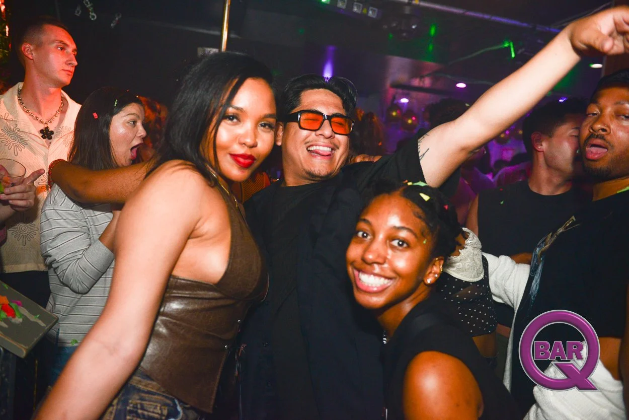 Group of young adults dancing and having fun at a nightclub or party, with colorful lighting and a lively atmosphere.
