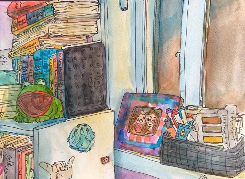A colorful watercolor illustration of a cluttered windowsill with books, a frog plush toy, a framed photo of two women, and various office supplies.