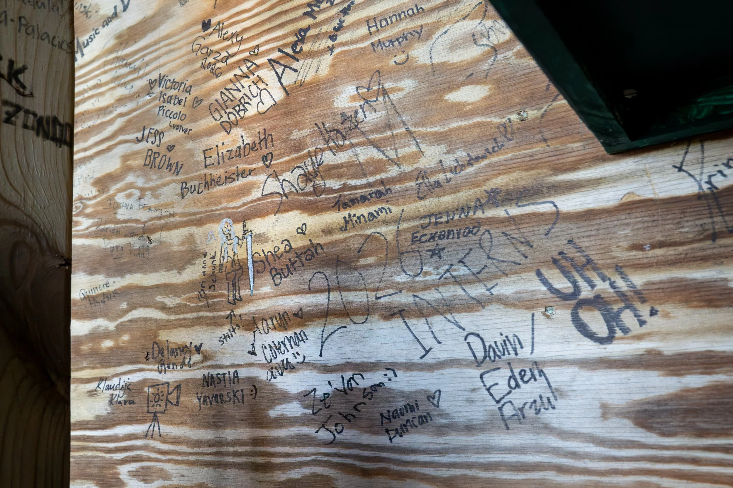 Interns follow the tradition of signing the wooden beam underneath the Henry J. Leir Stage following The PillowCase on Aug. 10, 2026.