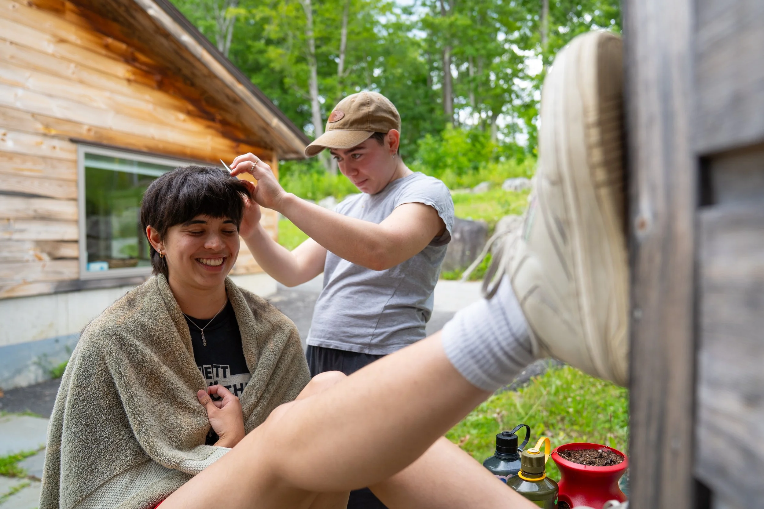 Jess Brown cuts Delaney Gondo’s hair outside of Overlook C staff housing on July 13, 2026.