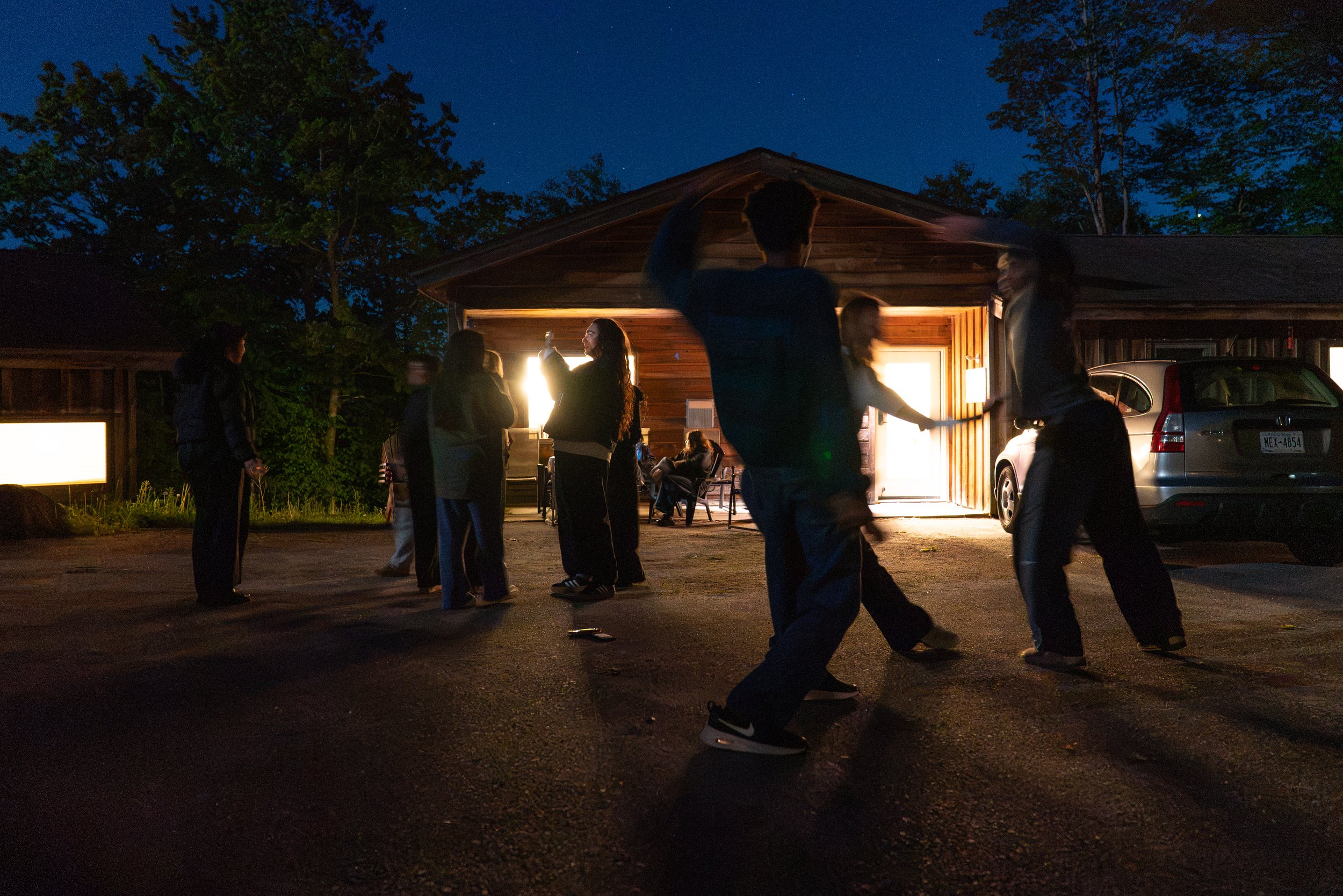 (From right) Z Johnson, Shea Hancock, and Eden Arzu do contact improv while other interns look at the Blue Moon and the stars outside of Overlook A staff housing on May 30, 2026.