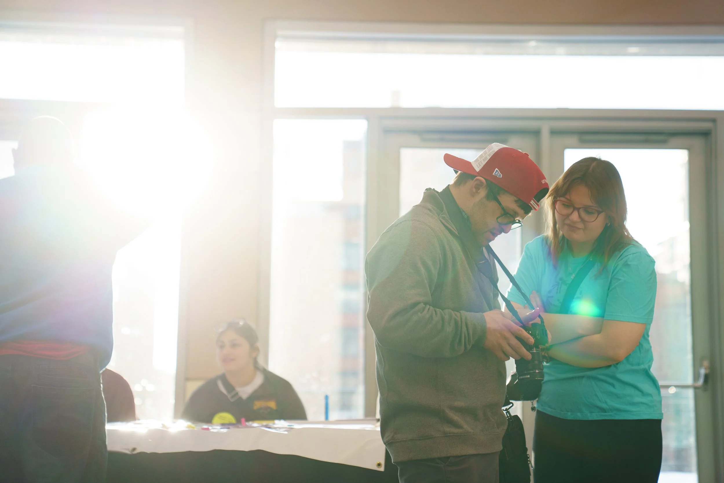 From left, Jude Killar and Samantha Vanburen look at his camera before the opening ceremonies for Special Olympics New York at Joseph A. Floreano Rochester Riverside Convention Center in Rochester, N.Y. on Feb. 20, 2026. “I love taking photos,” Killa