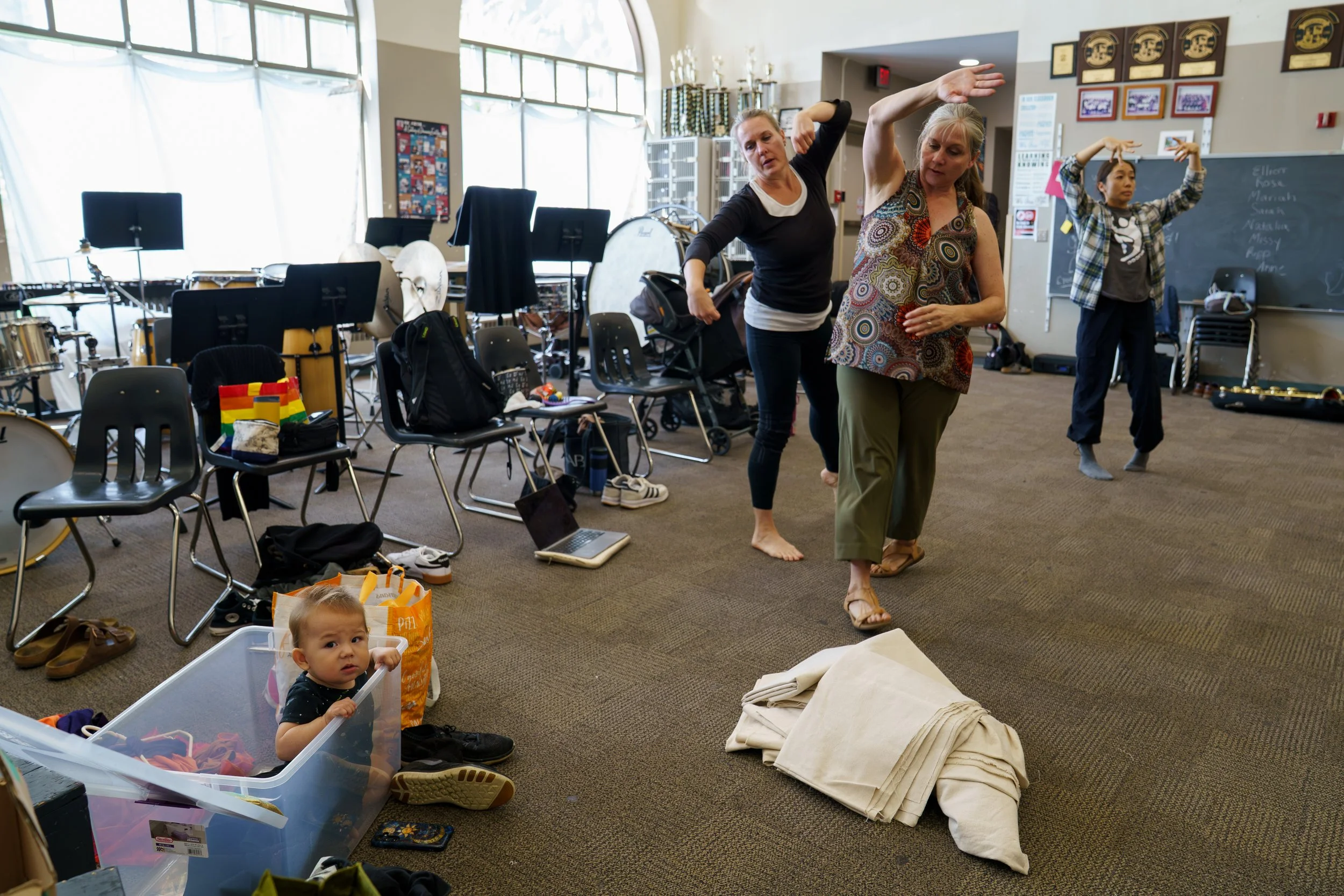 Dancers rehearse their piece backstage at Catch & Collide while Geo Mandrino sits in a plastic bin during ESL Rochester Fringe Festival at School of The Arts on Sept. 24, 2025 in Rochester, N.Y. Mandrino’s mother Nanako Mandrino was a dancer in “Conn