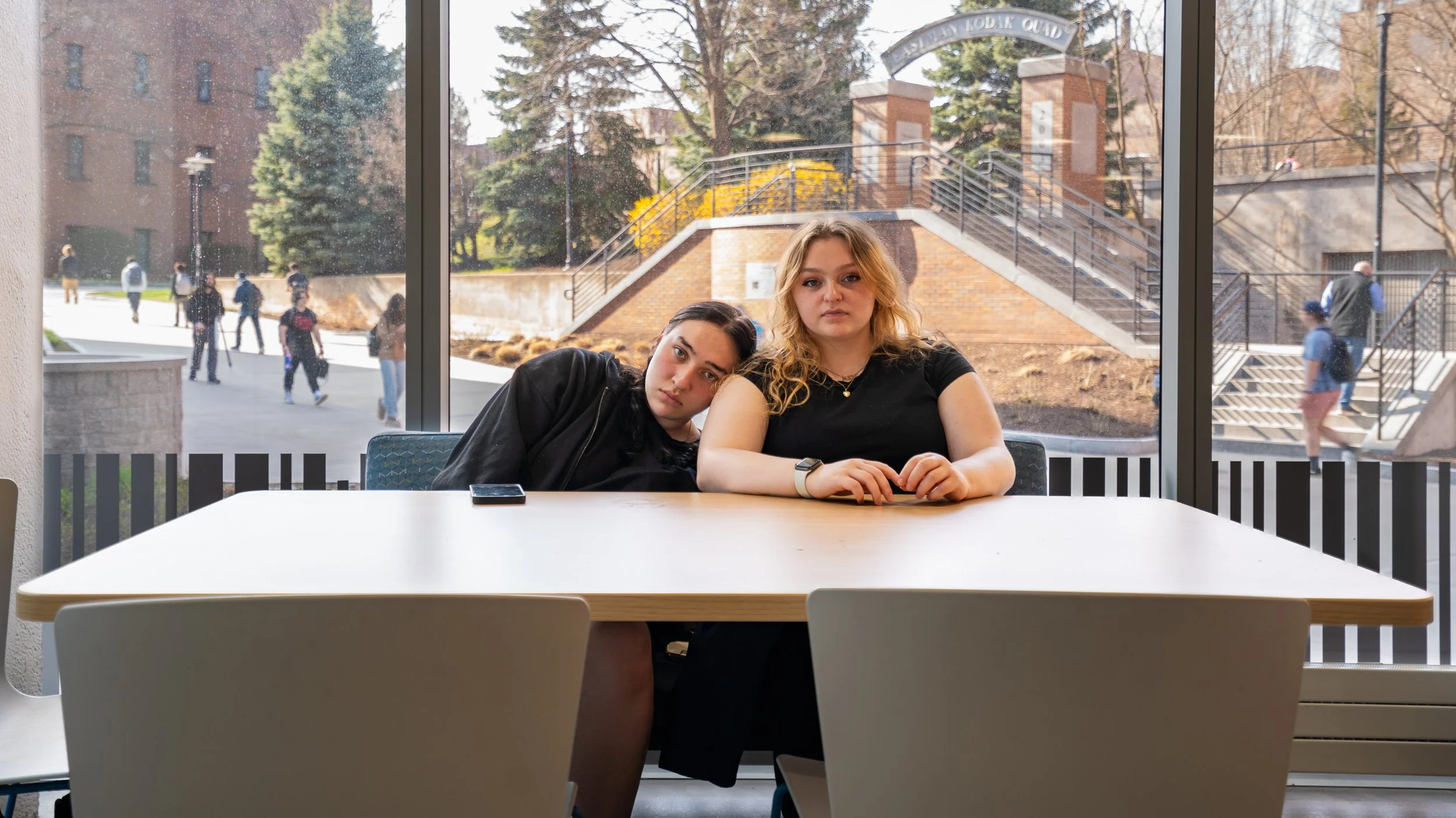 Madi and Alicia both pose for a portrait in Artesano’s Bakery and Cafe in Monroe Hall at Rochester Institute of Technology on Apr. 27, 2025 in Rochester, N.Y. Despite their busy schedules and chaos of daily life, Madi and Alicia sit together at Artes