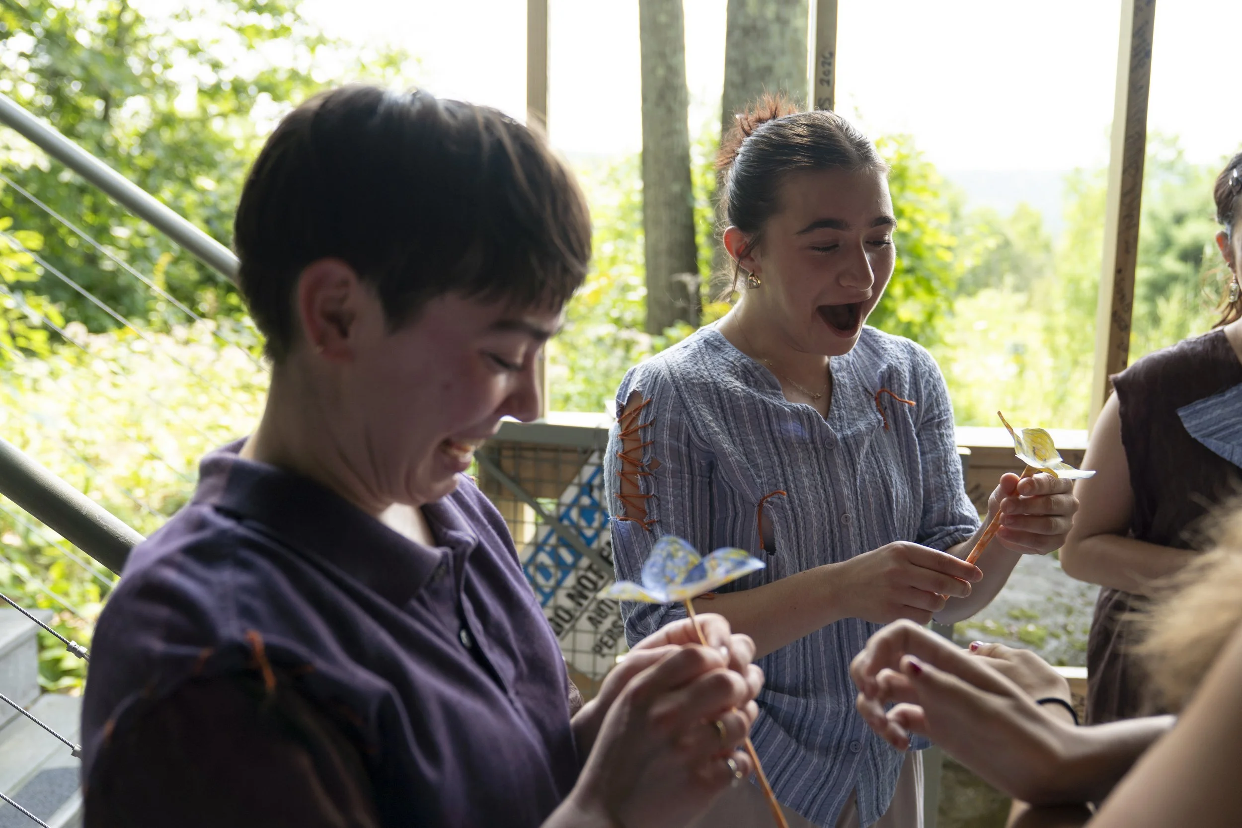 (From left) Jess Brown and Gianna Dobrich receive homemade paper flowers from Jenna Eckenrod as a “thank you” for being involved in “Grace Period” backstage before The PillowCase on Aug. 10, 2026.