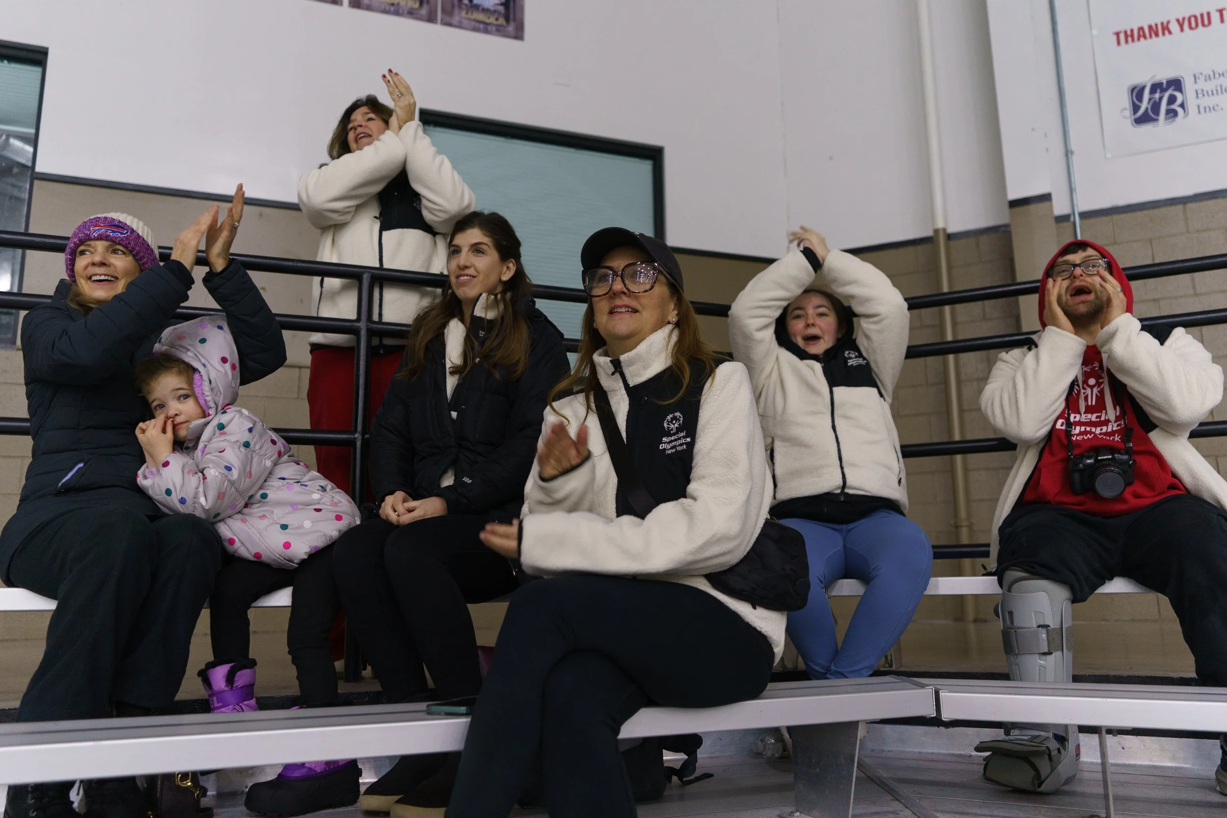 From left, Karen Fischer, Sasha Massa, Stacey Hengsterman, Sara Massa, Stacy Eder, Summer Sledge, and Jude Killar cheer for athletes during figure skating at Tim Horton’s Ice Complex in Brighton, N.Y. on Feb. 21, 2026. “Special Olympics means a lot t