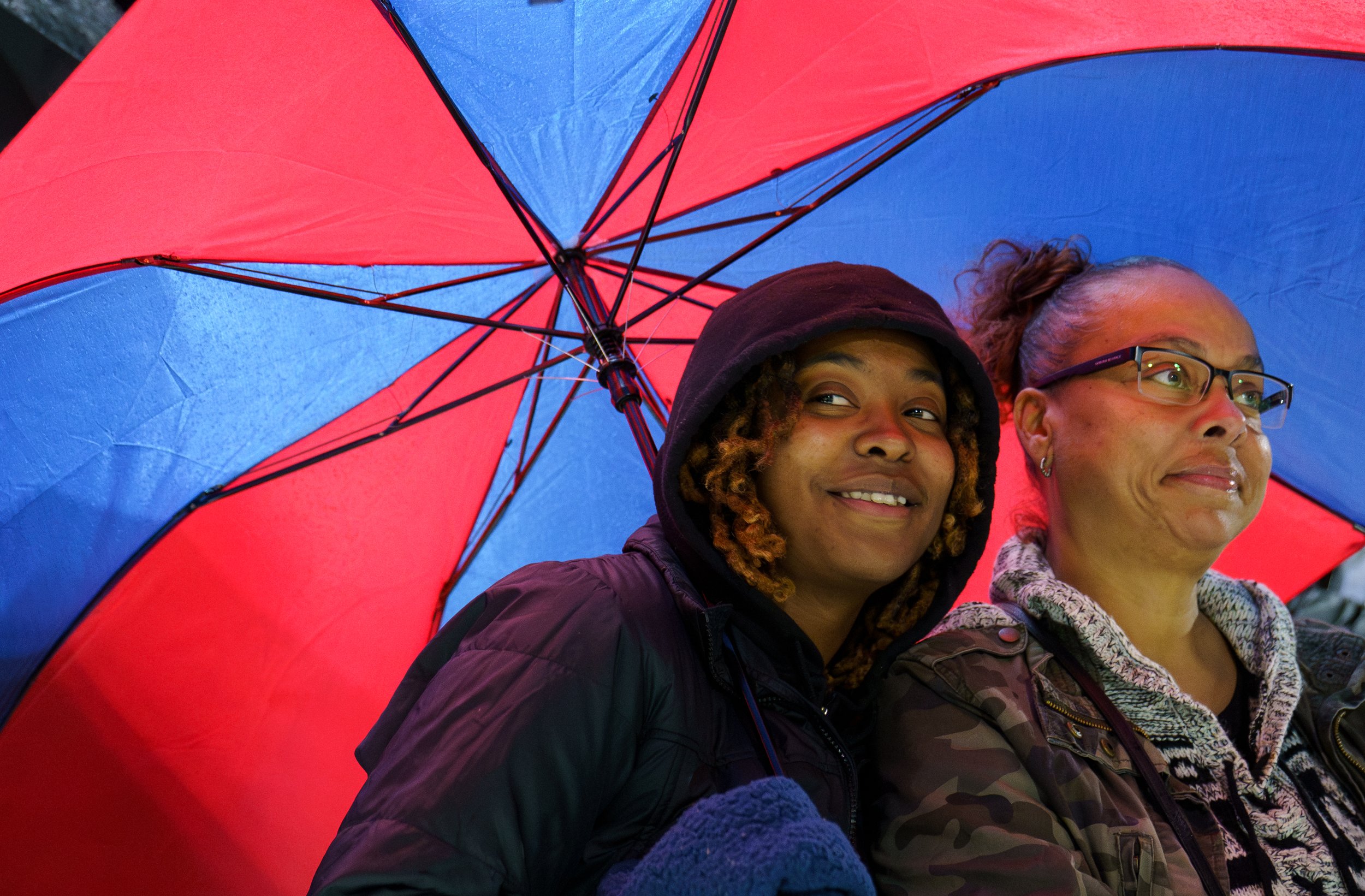 Sarabi (left) and Nichole (right) Wagstaff shelter from the rain in the fan section of Greece Olympia/Odyssey High School Football vs. Rush-Henrietta High School Football game to support their family member Imani Wagstaff at Greece Olympia/Odyssey Hi