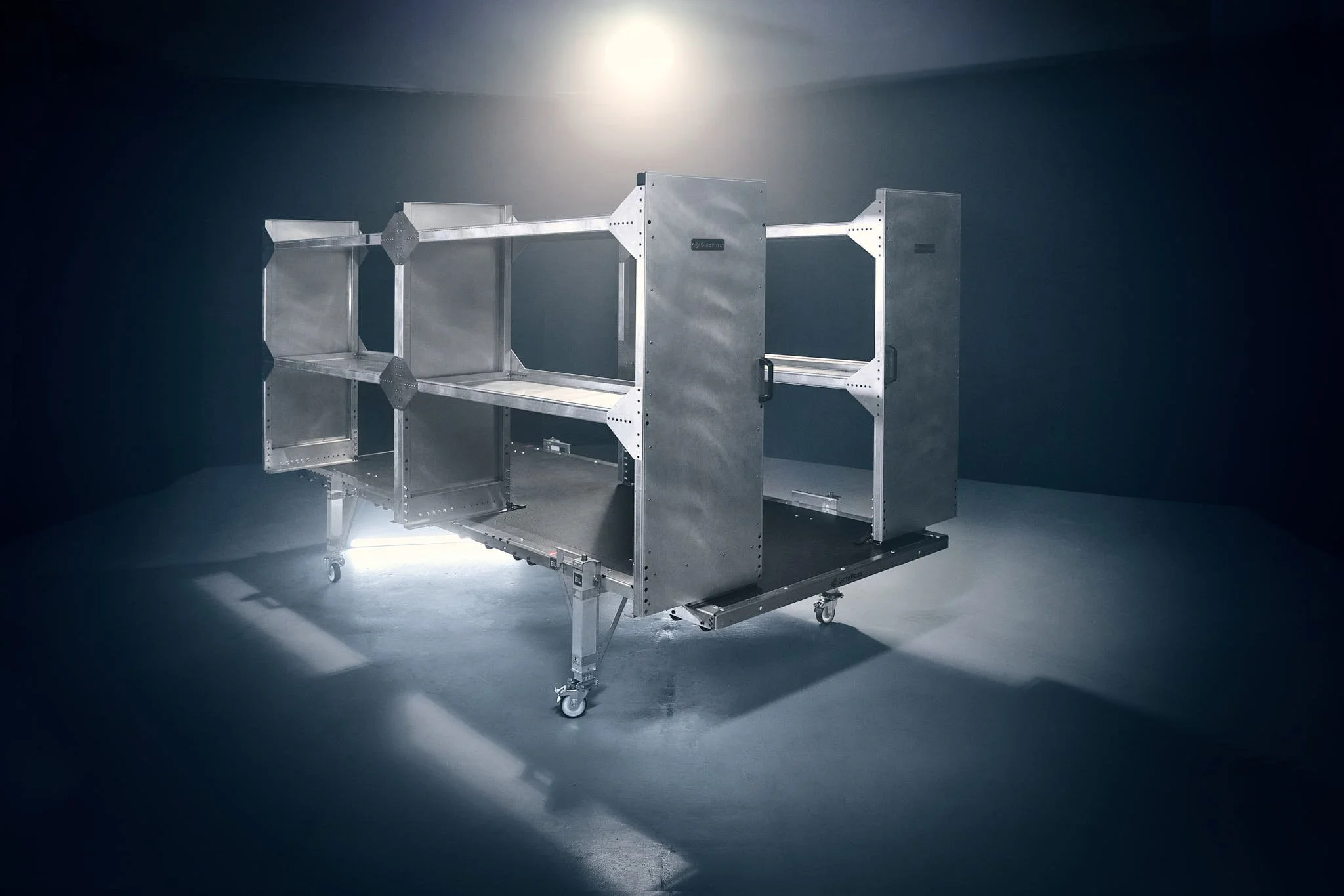A  metallic removable cargo van upfit with shelves, set against a dark background with focused lighting.