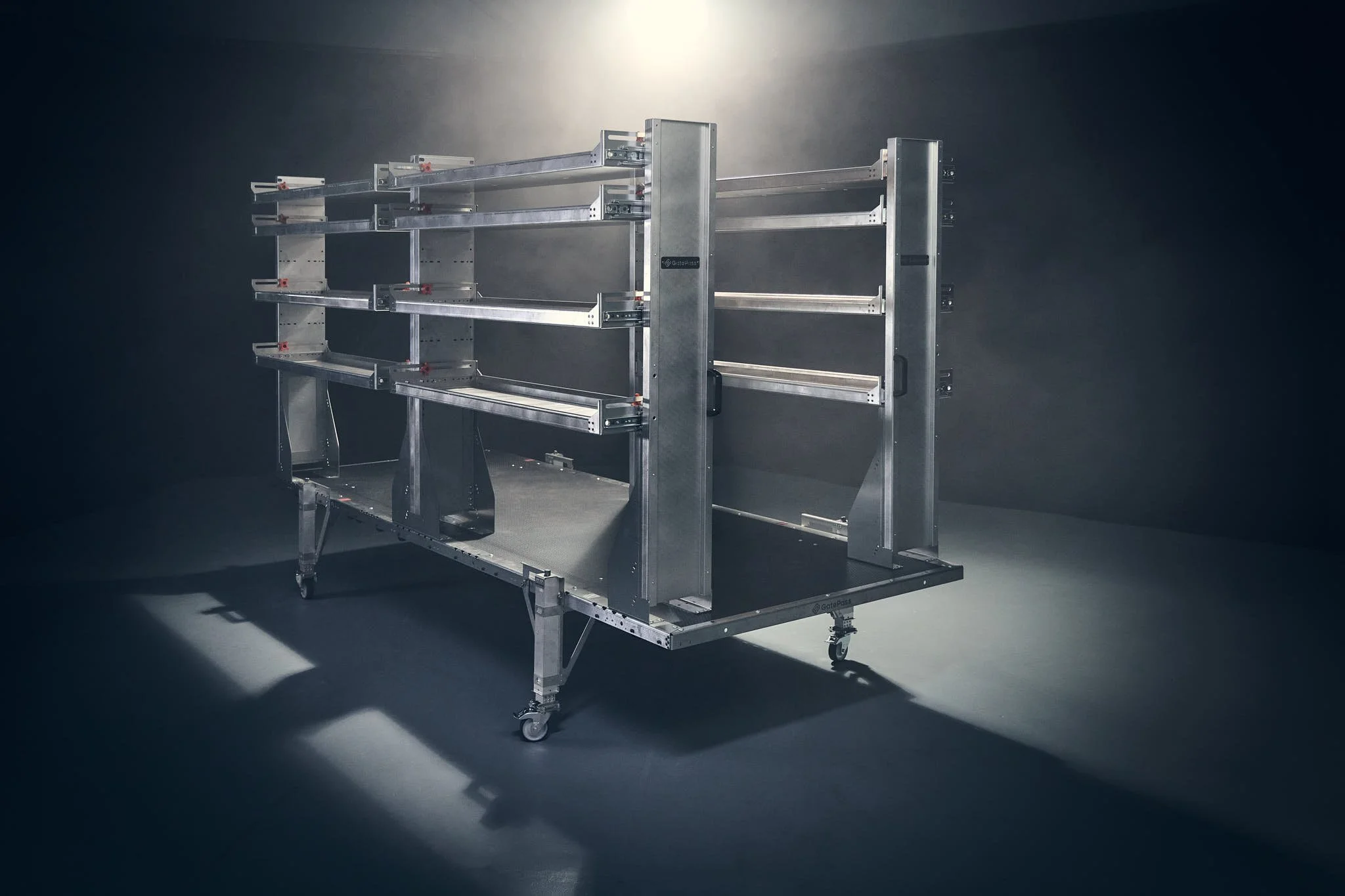 A metallic removable cargo van upfit with shelves, set against a dark background with spotlighting.