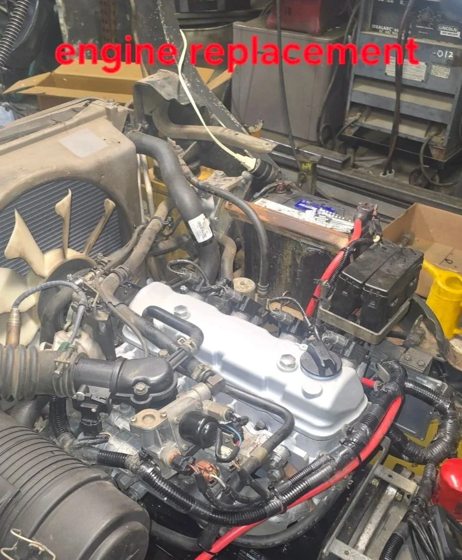 An engine in a garage workshop with the words 'engine replacement' written in red overlay.