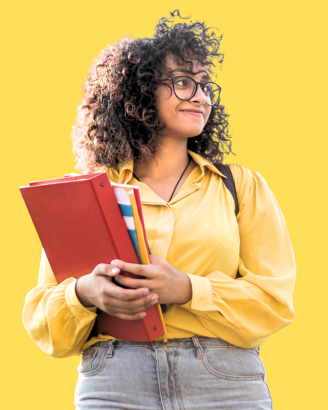 Young woman with curly hair, glasses, and a yellow shirt holding books against a yellow background.