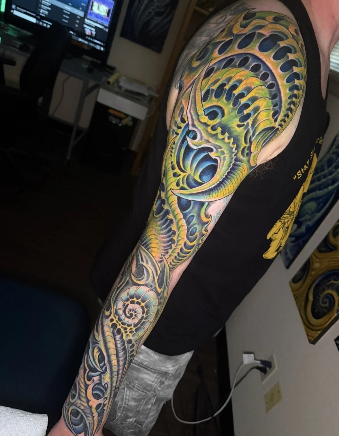 Colorful tattoo of a ammonite fossil on a person's arm, depicting intricate details and vibrant colors.