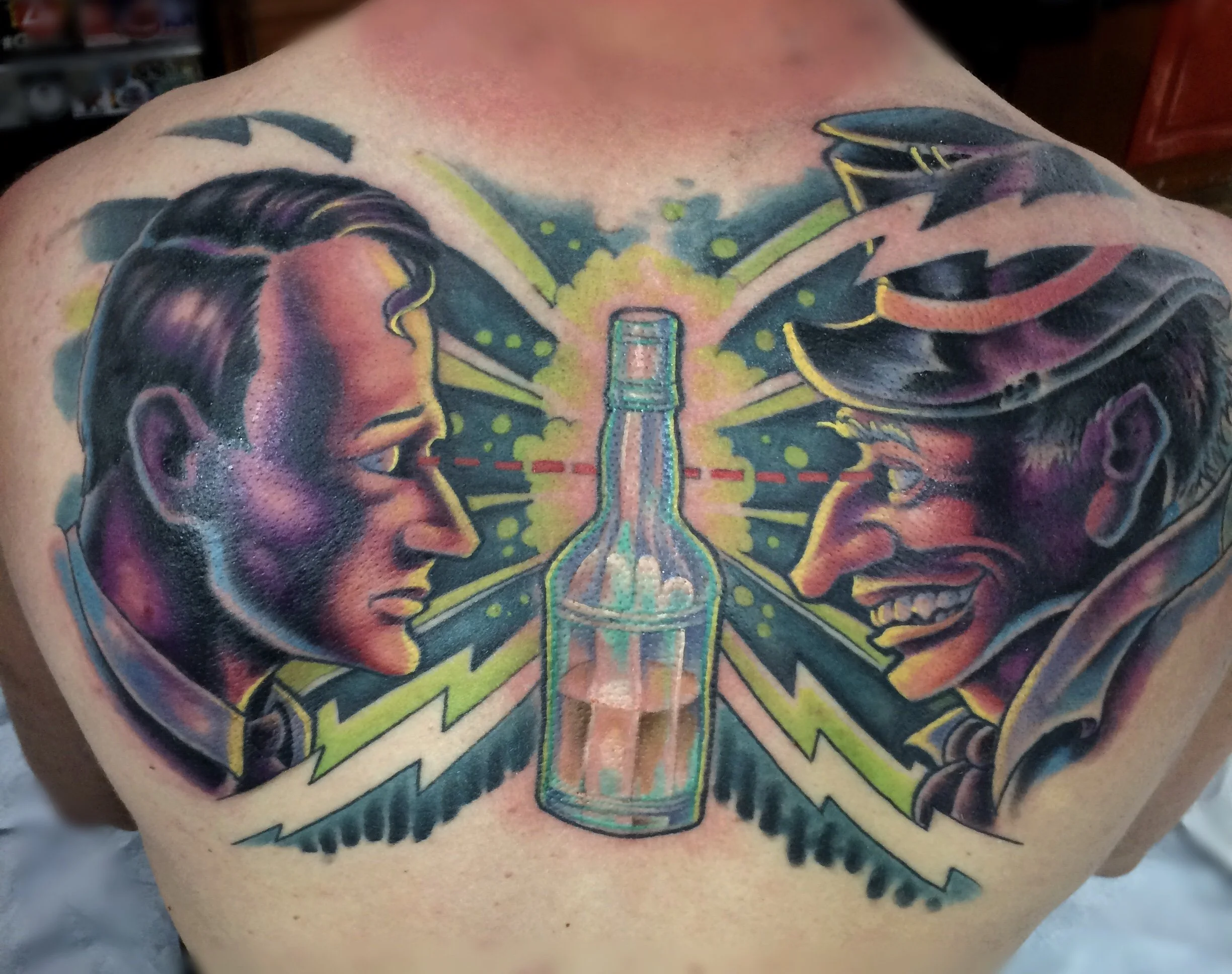 Colorful tattoo of a cartoon-style beer mug with foam at the top, flanked by two human profiles in profile view, one on each side, with faces looking towards the beer mug.
