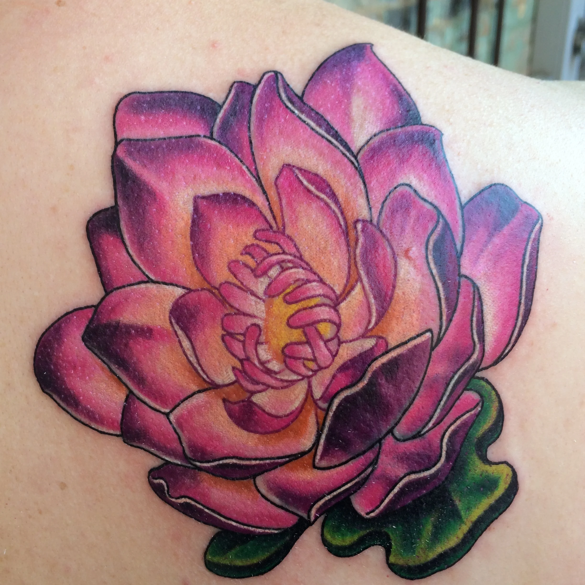 Colorful tattoo of a rose flower on a person's skin.