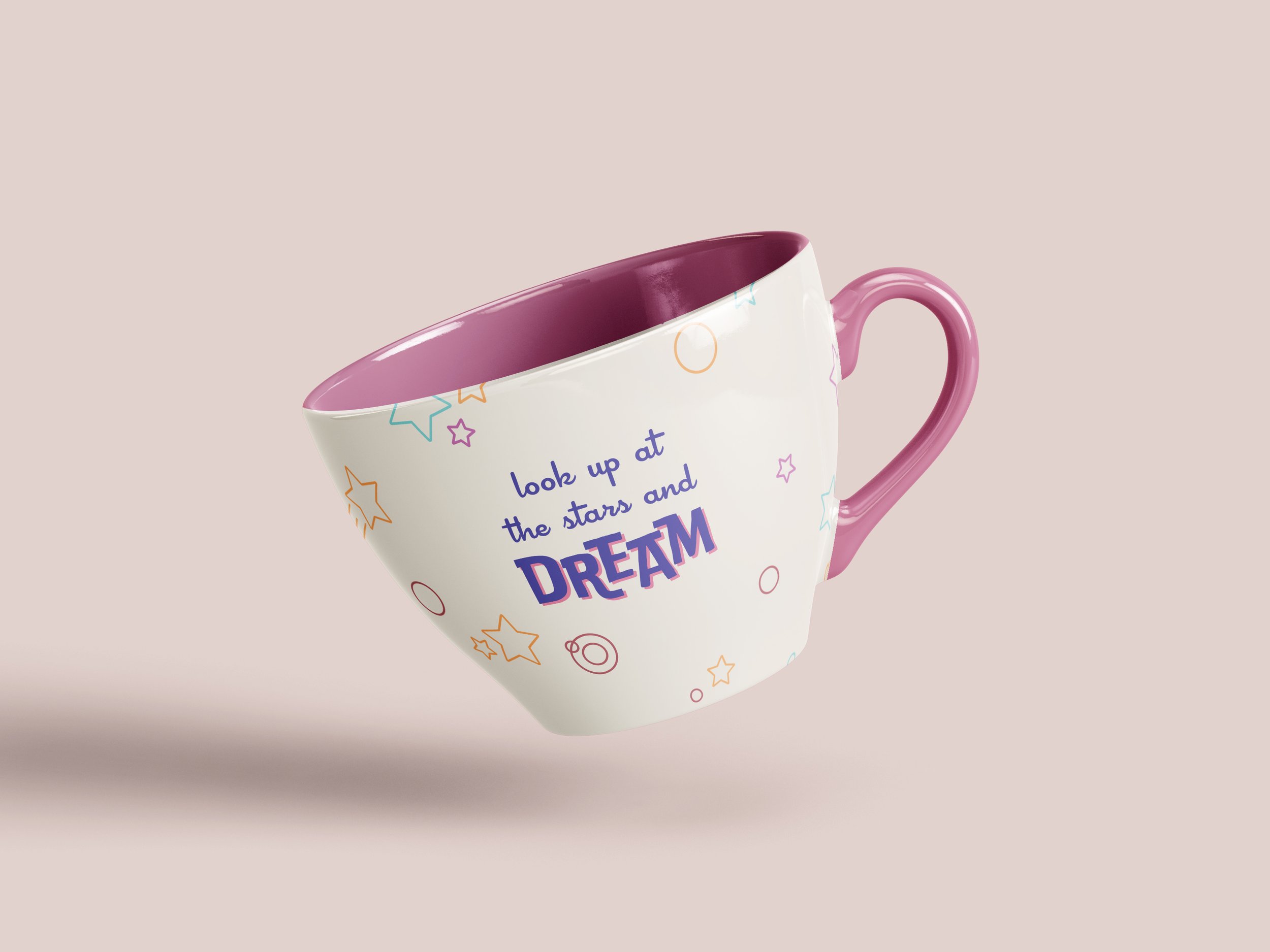 A white ceramic mug with pink handle and interior, decorated with colorful stars, circles, and the text 'look up at the stars and dream'.