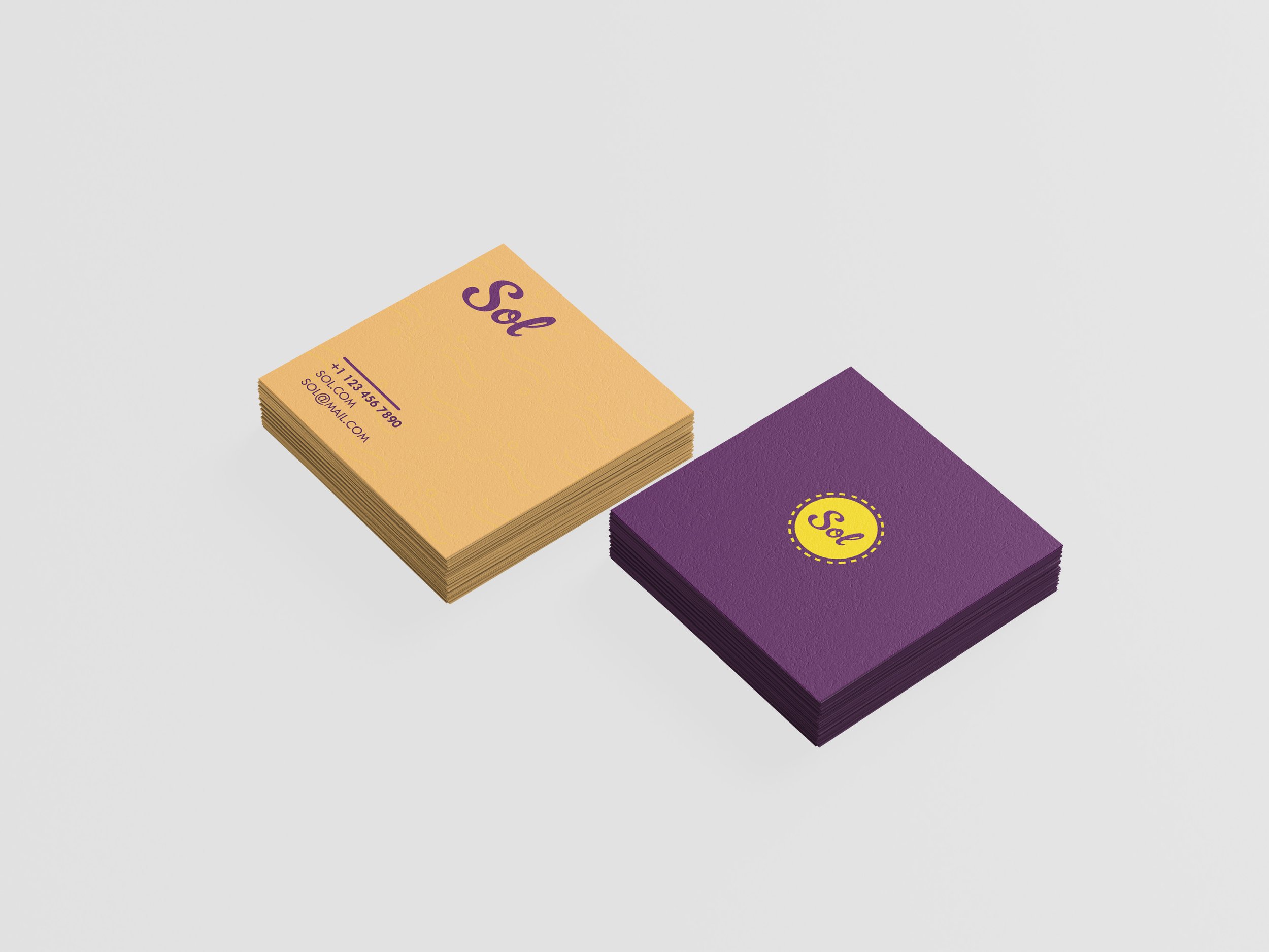 Stacks of business cards, one yellow with purple text and one purple with yellow text, placed on a white surface.
