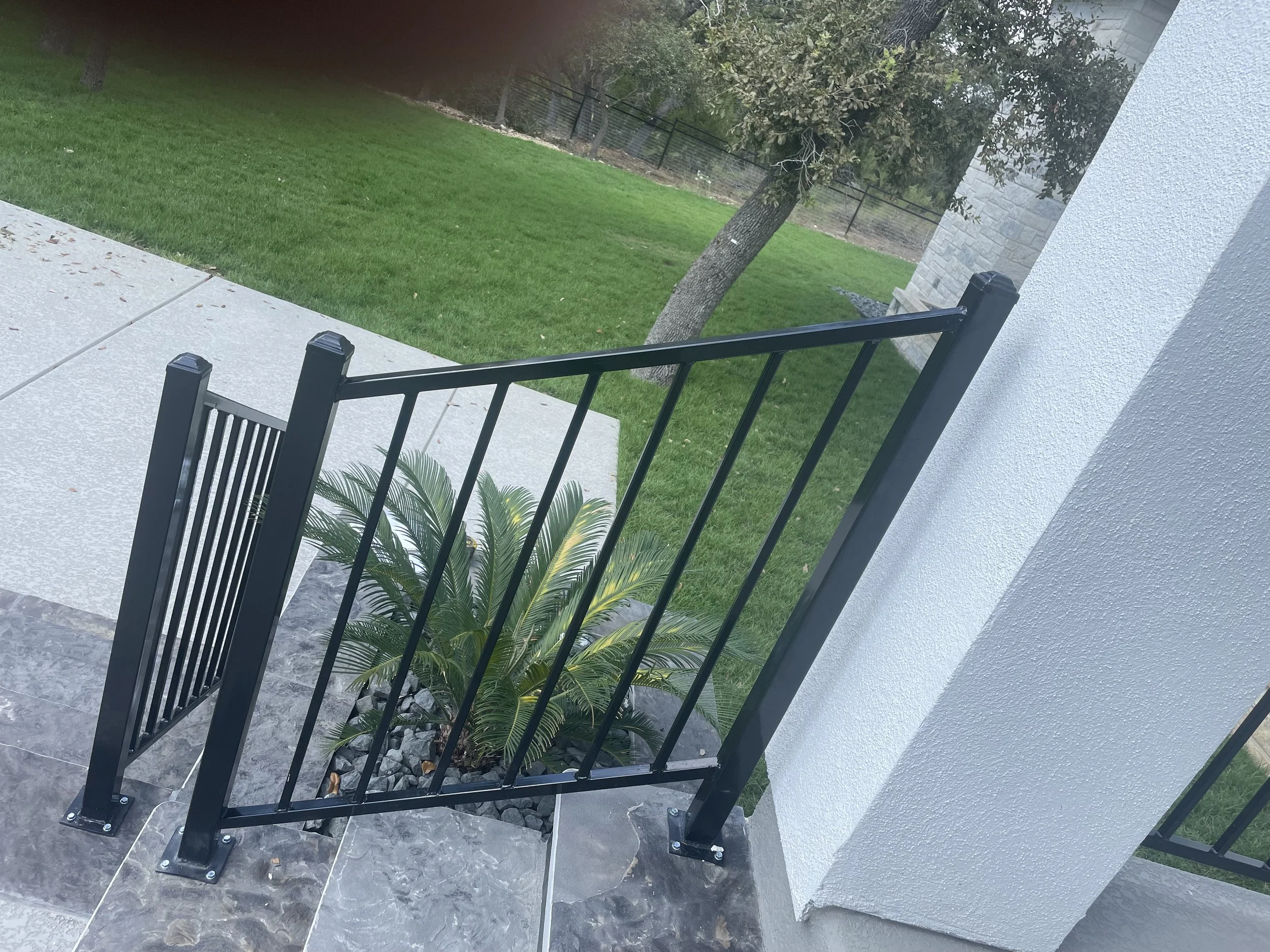 Black wrought iron railing on steps.