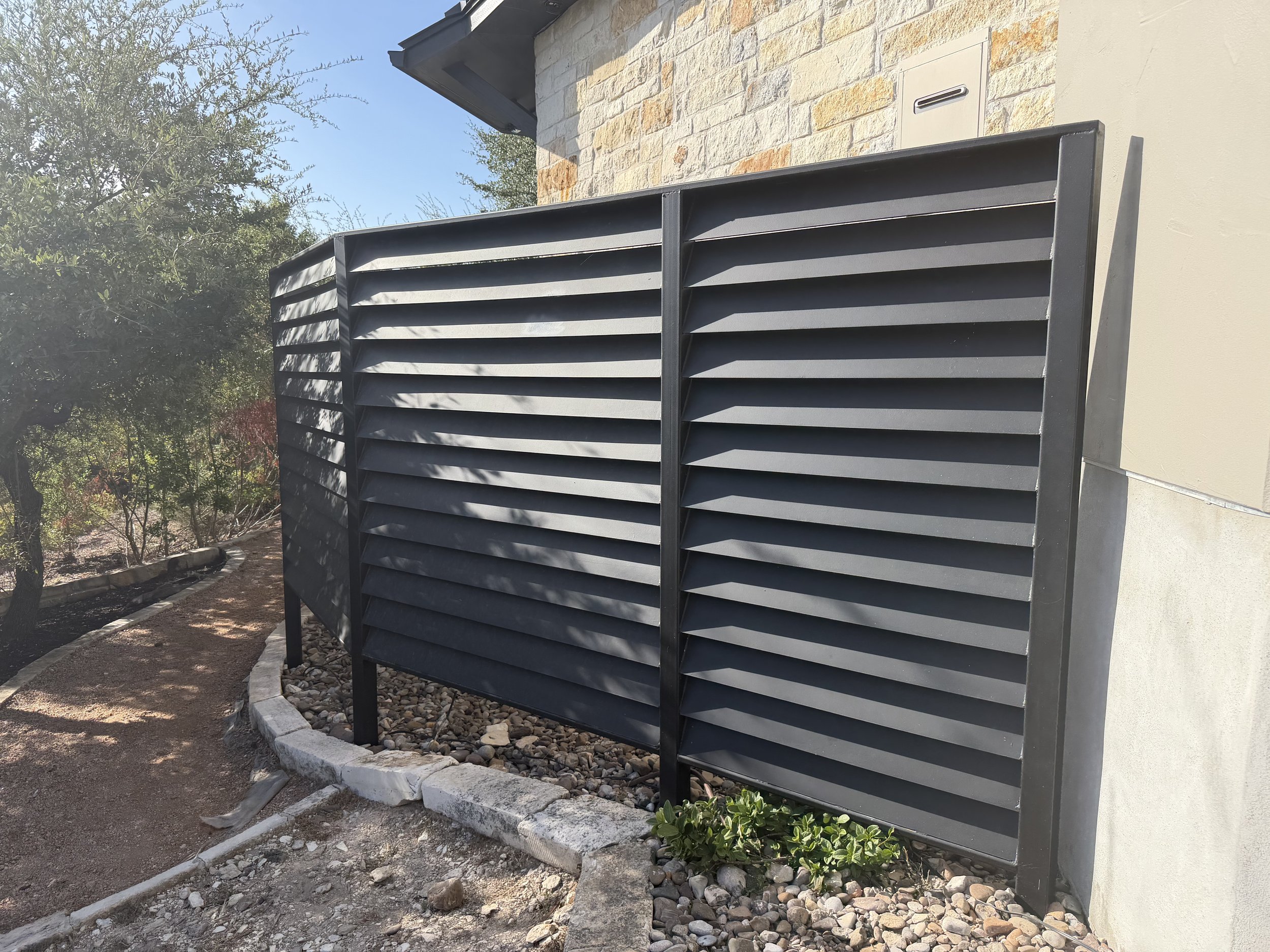 Screened metal louvered partial enclosure surrounding pool equipment.