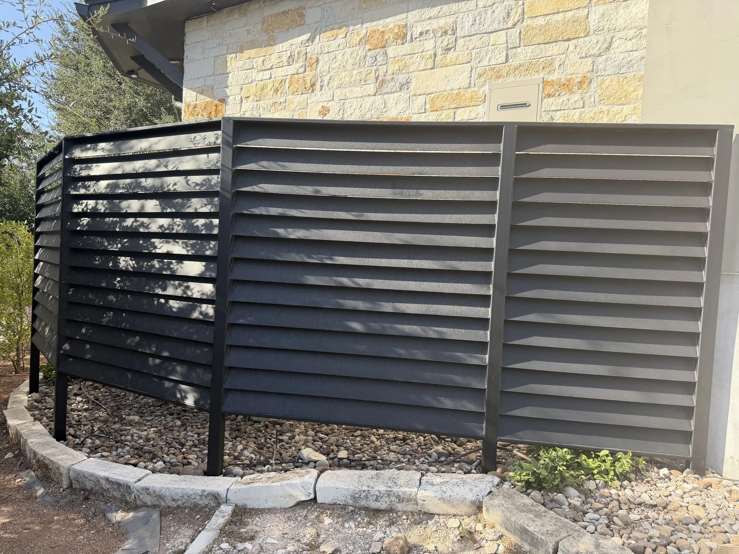 Screened metal louvered partial enclosure surrounding pool equipment.