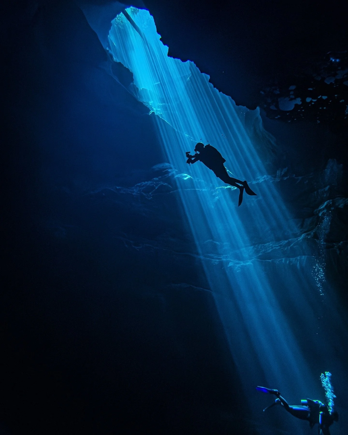 How deep could I be? Dropping rapidly through the small crack in the rocks, sunlight streams down around me as I fall through the cool darkness. It must be, what? 50 feet? 60? I check my dive computer - I&rsquo;m already at 90&rsquo; and still droppi