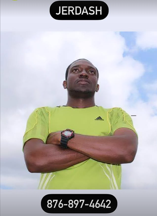A man standing outdoors against a cloudy sky, wearing a bright yellow athletic shirt, with arms crossed, a watch on his left wrist, and a serious expression. Text at the top says 'JERDASH' and at the bottom is a phone number '876-897-4642'.