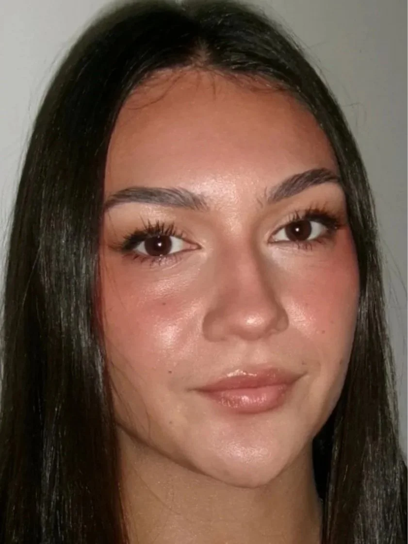 Close-up photo of a young woman with long dark hair, light makeup, and a slight smile.