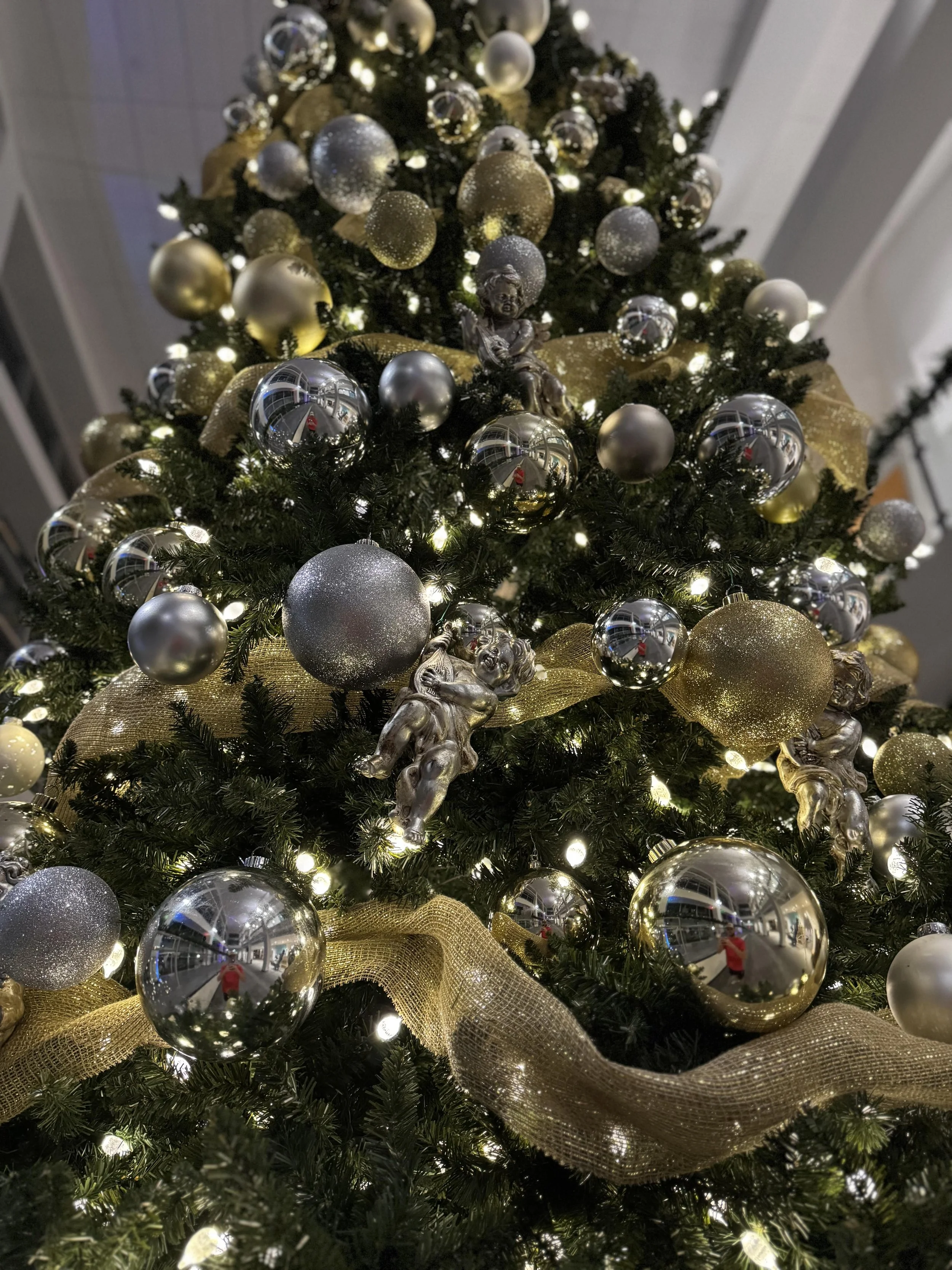 silver-gold-ornaments-lit-commercial-christmas-tree-closeup.jpg