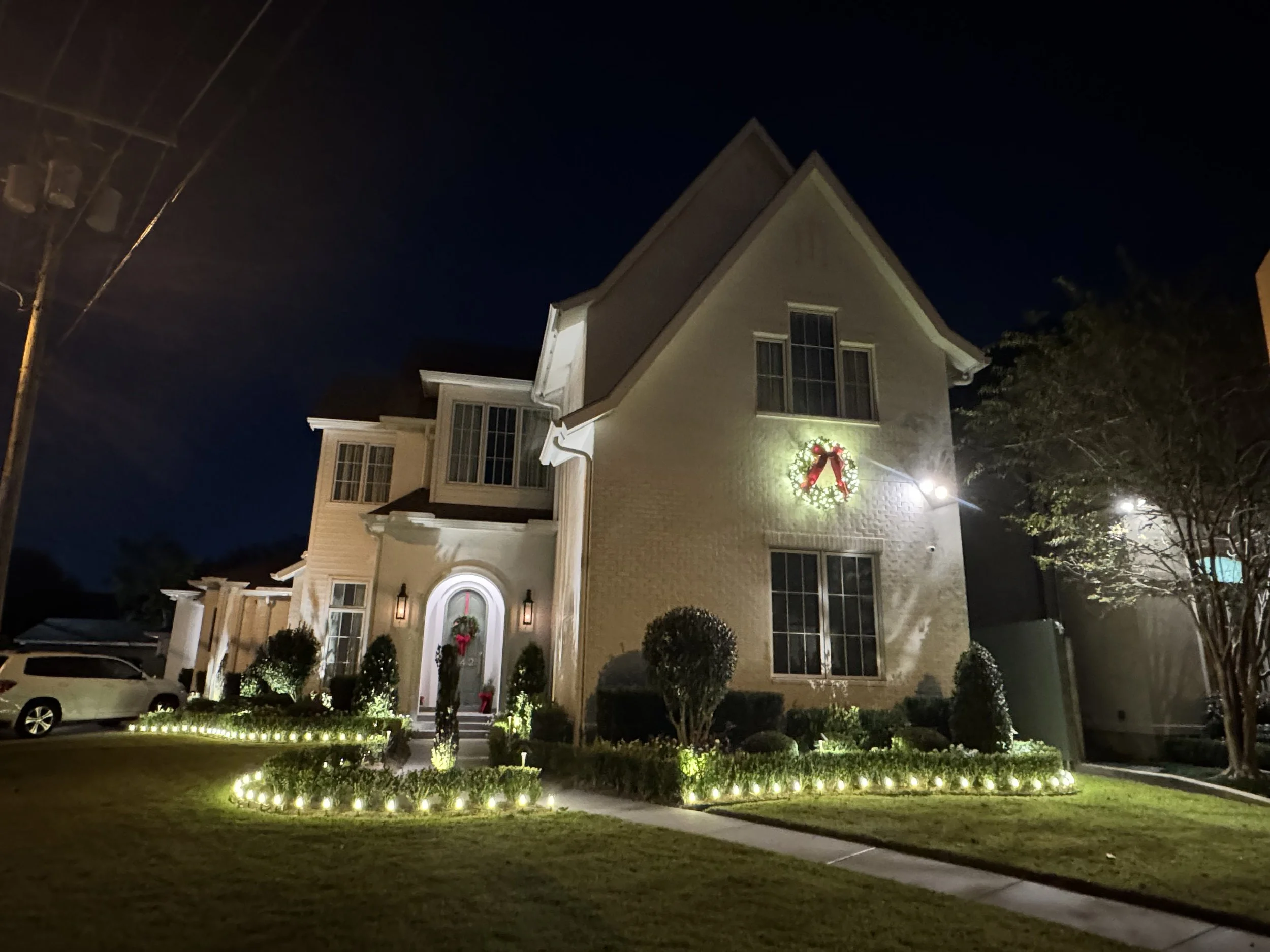 warm-white-landscape-lights-two-story-home-wreaths.jpg